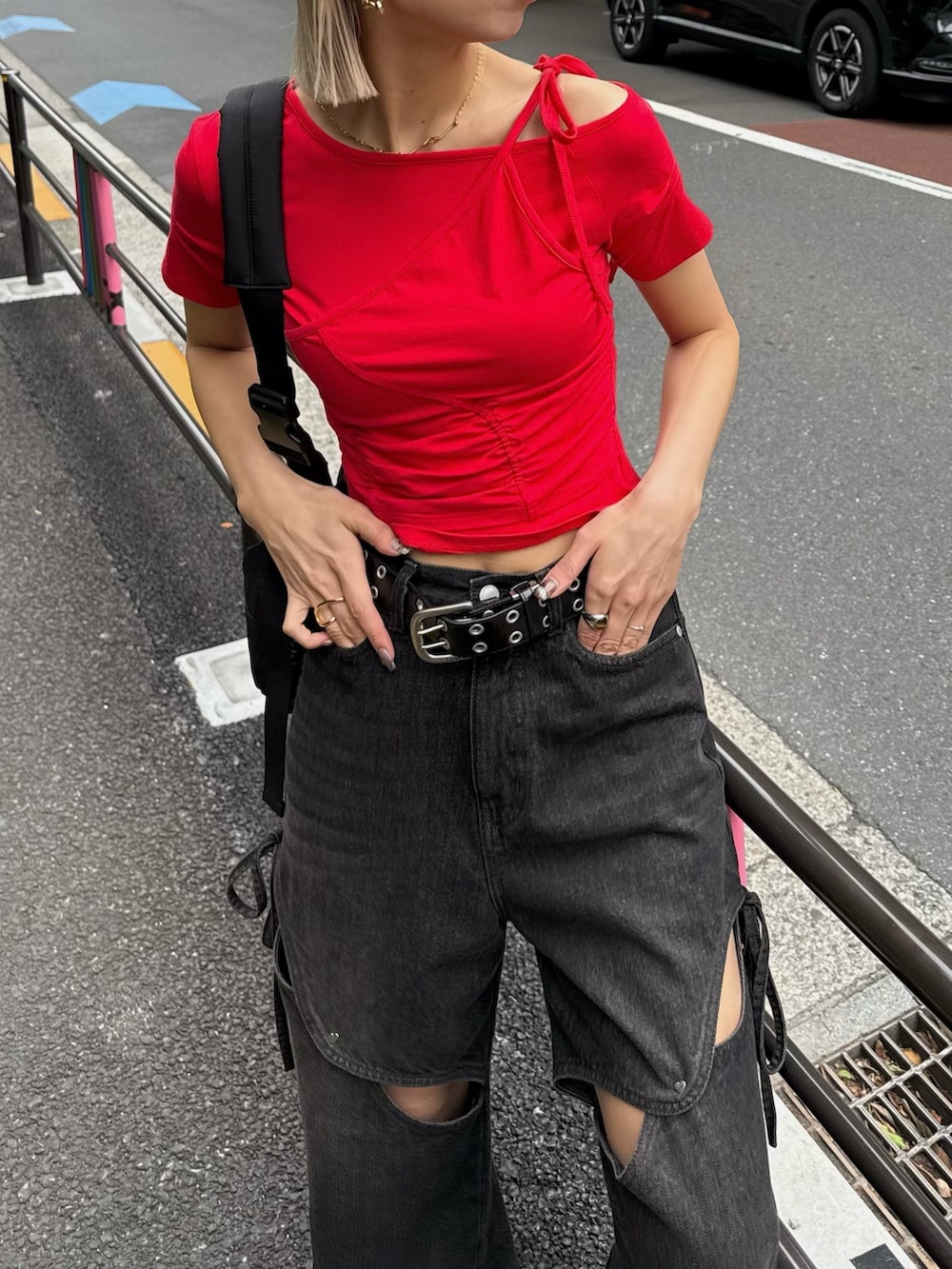 レッド系のTシャツ/カットソー、ブラック系のデニムパンツ、グレー系のハンチング/ベレー帽を着用したレディースの夏コーディネートの3枚目の写真