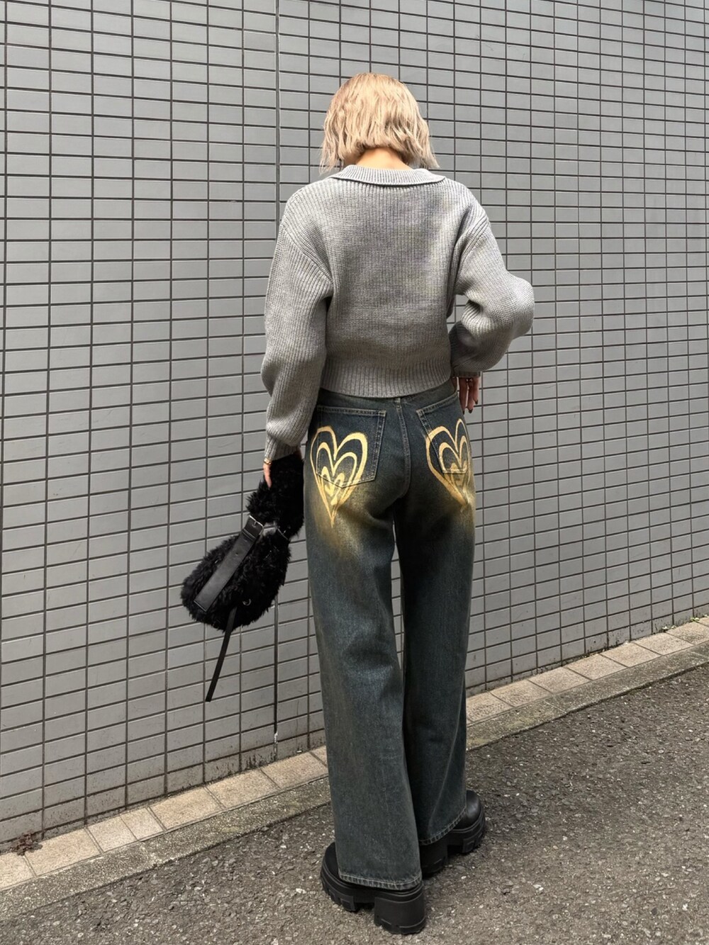 グレー系のニット/セーター、ブルー系のデニムパンツ、ブラック系のショルダーバッグを着用したレディースの冬コーディネートの5枚目の写真