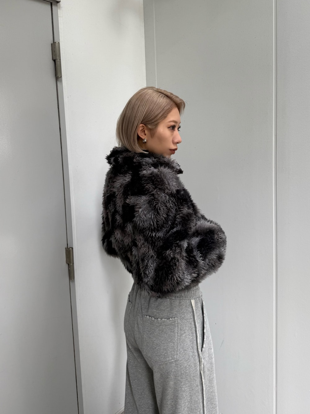 ブルー系のブルゾン、グレー系のスウェットパンツ、ブラック系のブーツを着用したレディースの秋コーディネートの5枚目の写真