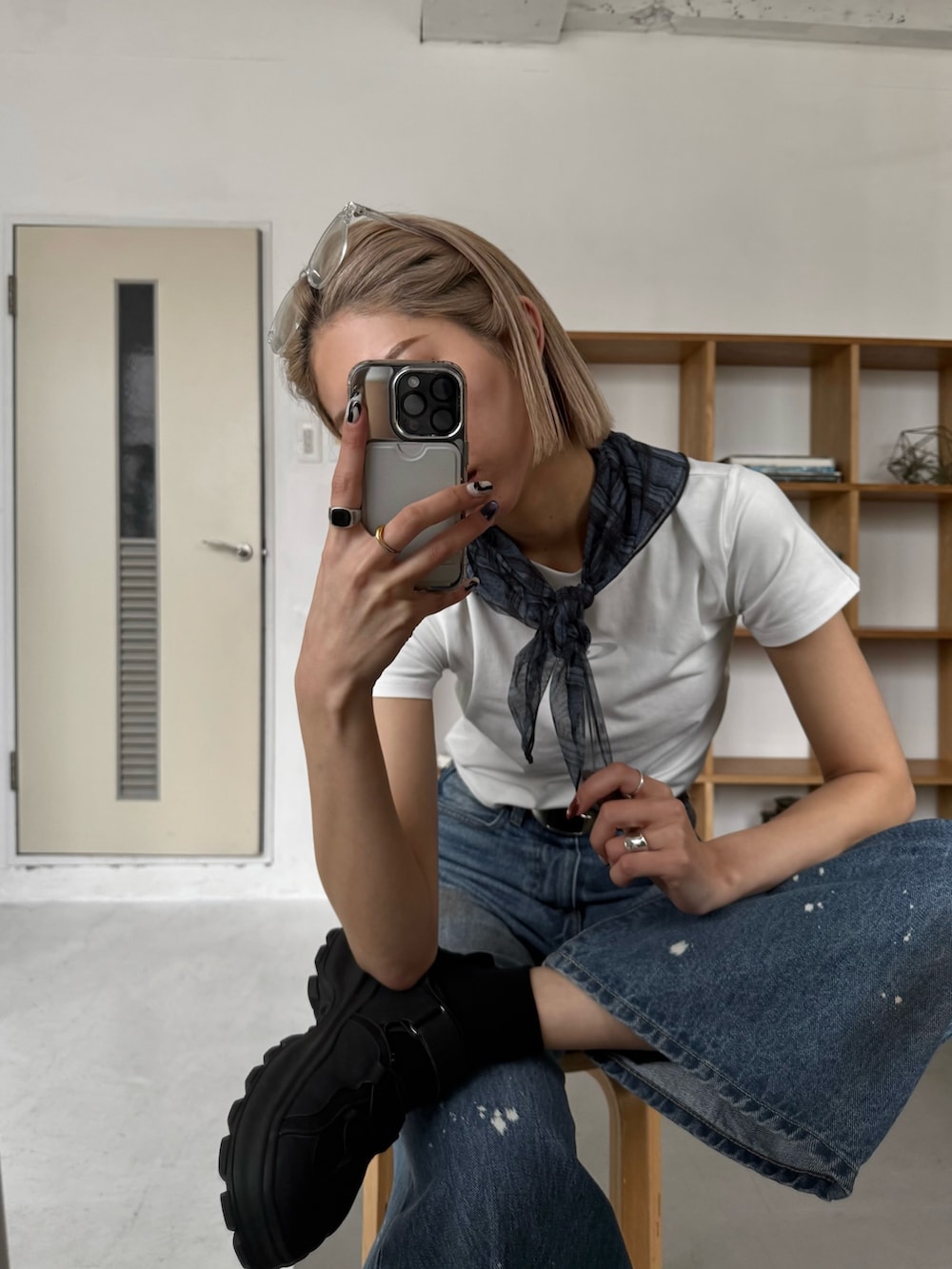 ブルー系のデニムパンツ、ブラック系のハンドバッグ、ブラック系のサンダルを着用したレディースの春コーディネートの3枚目の写真