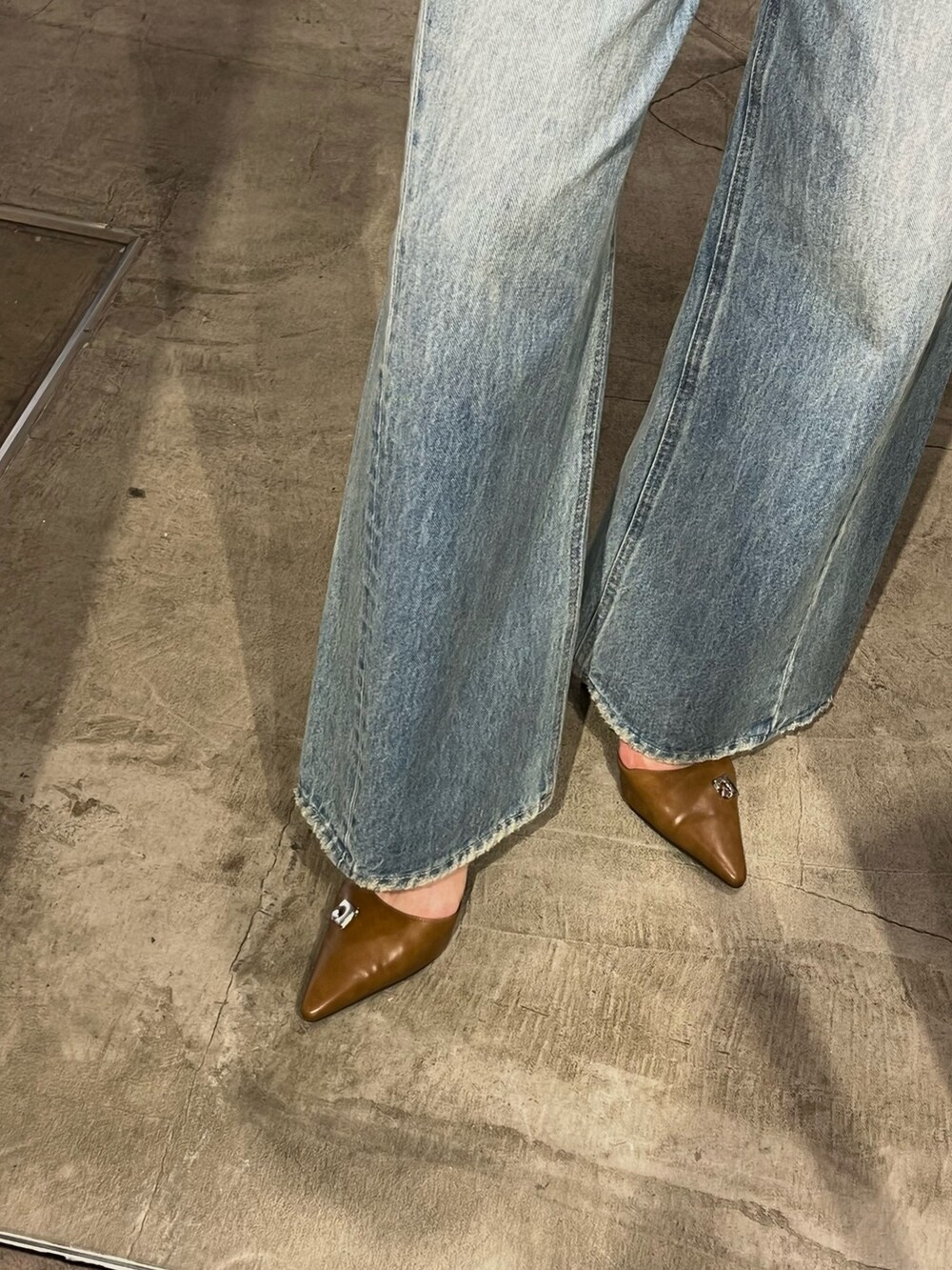 ブラック系のブルゾン、ブルー系のデニムパンツ、ブラウン系のパンプスを着用したレディースの春コーディネートの4枚目の写真