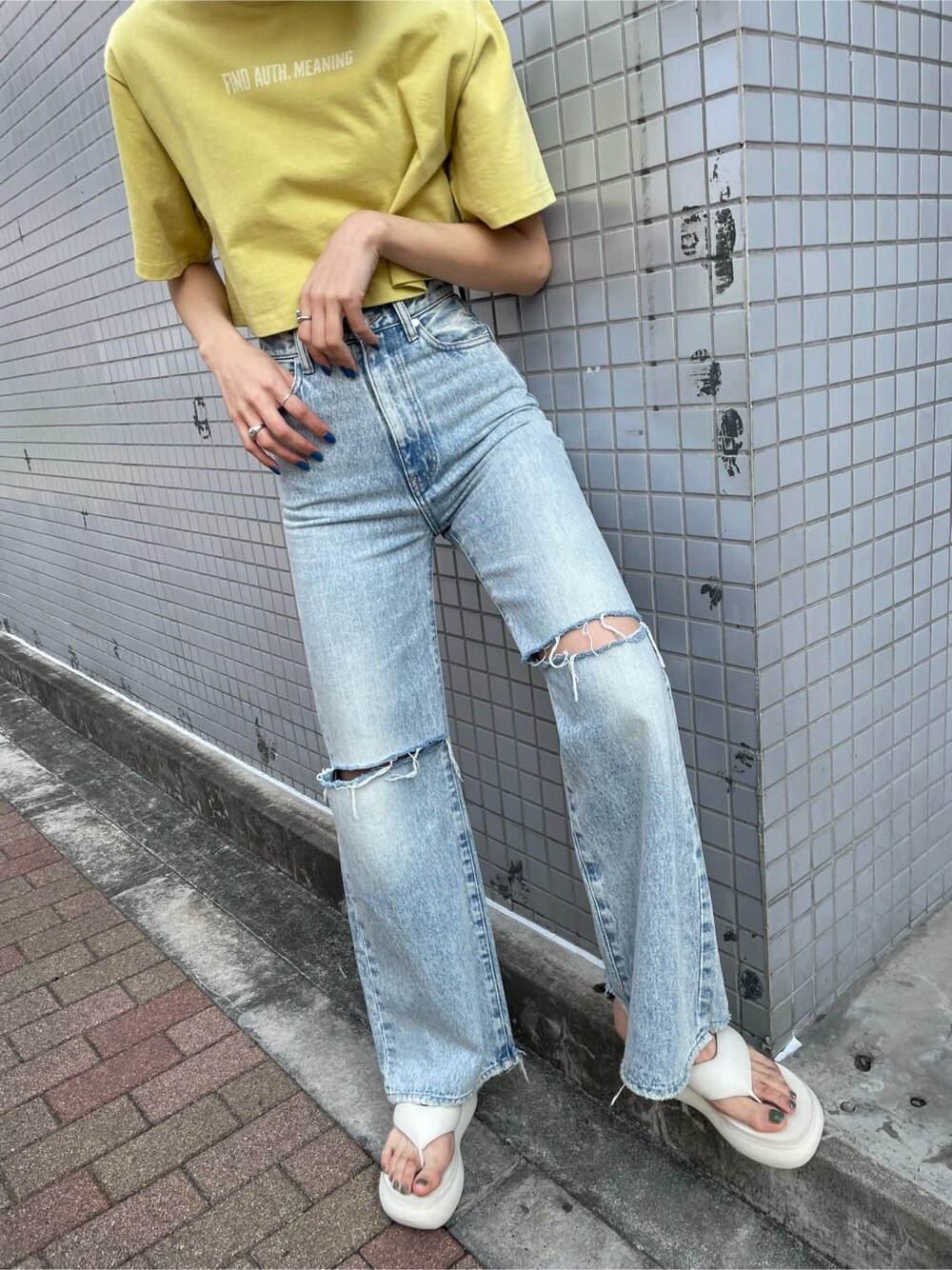 ブルー系のデニムパンツ、イエロー系のTシャツ/カットソー、ホワイト系のサンダルを着用したレディースの春コーディネートの6枚目の写真