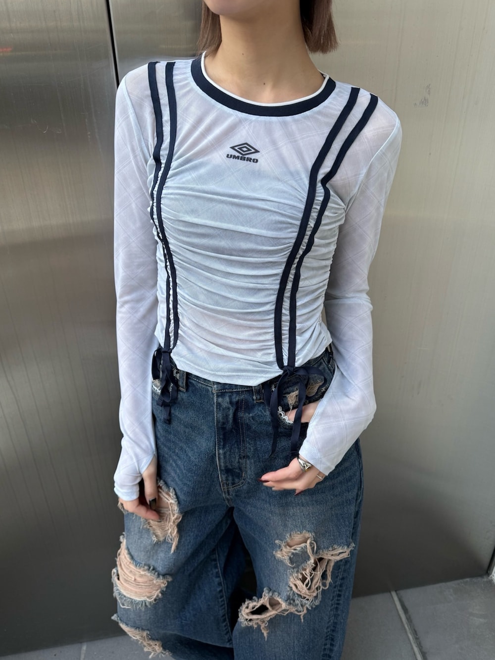 ブルー系のデニムパンツ、ホワイト系のTシャツ/カットソー、ブラック系のスニーカーを着用したレディースの冬コーディネートの3枚目の写真