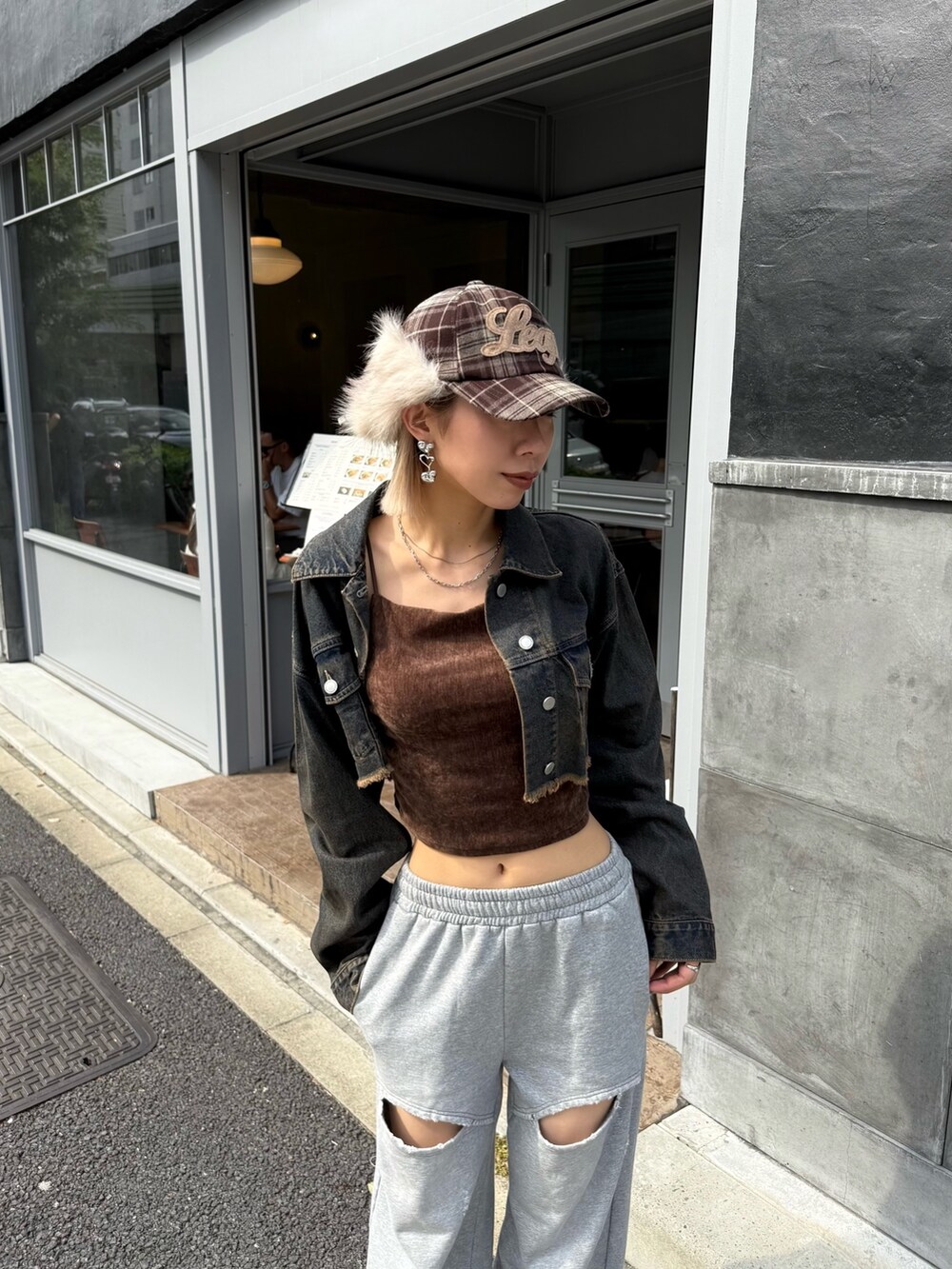 ブルー系のデニムジャケット、グレー系のスウェットパンツ、ベージュ系のキャップを着用したレディースの秋コーディネートの3枚目の写真