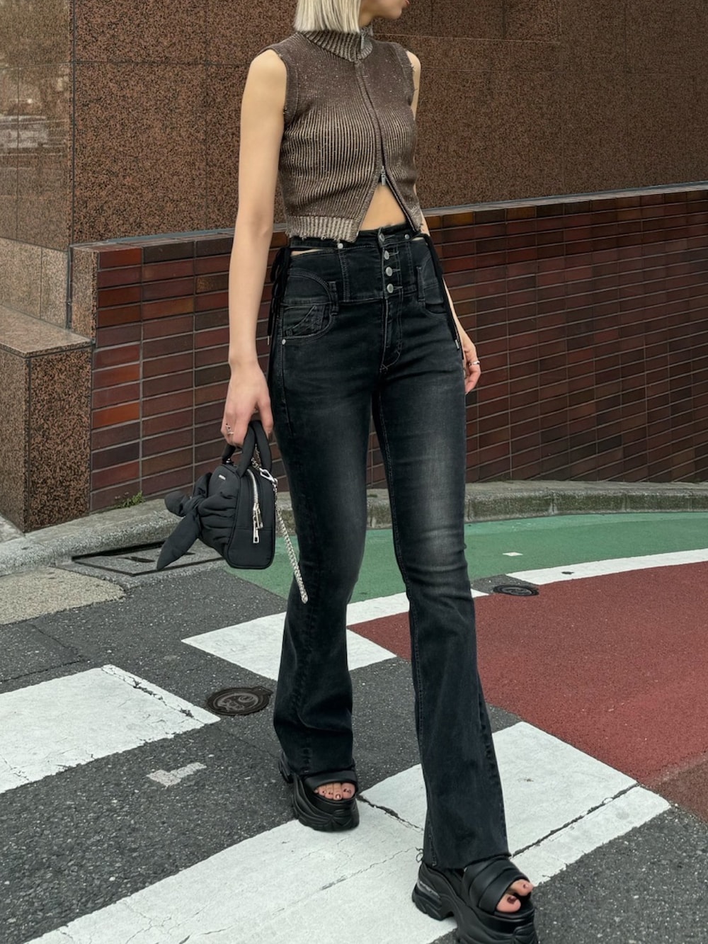 ブラック系のデニムパンツ、ブラック系のハンドバッグ、ブラック系のサンダルを着用したレディースの夏コーディネートの5枚目の写真