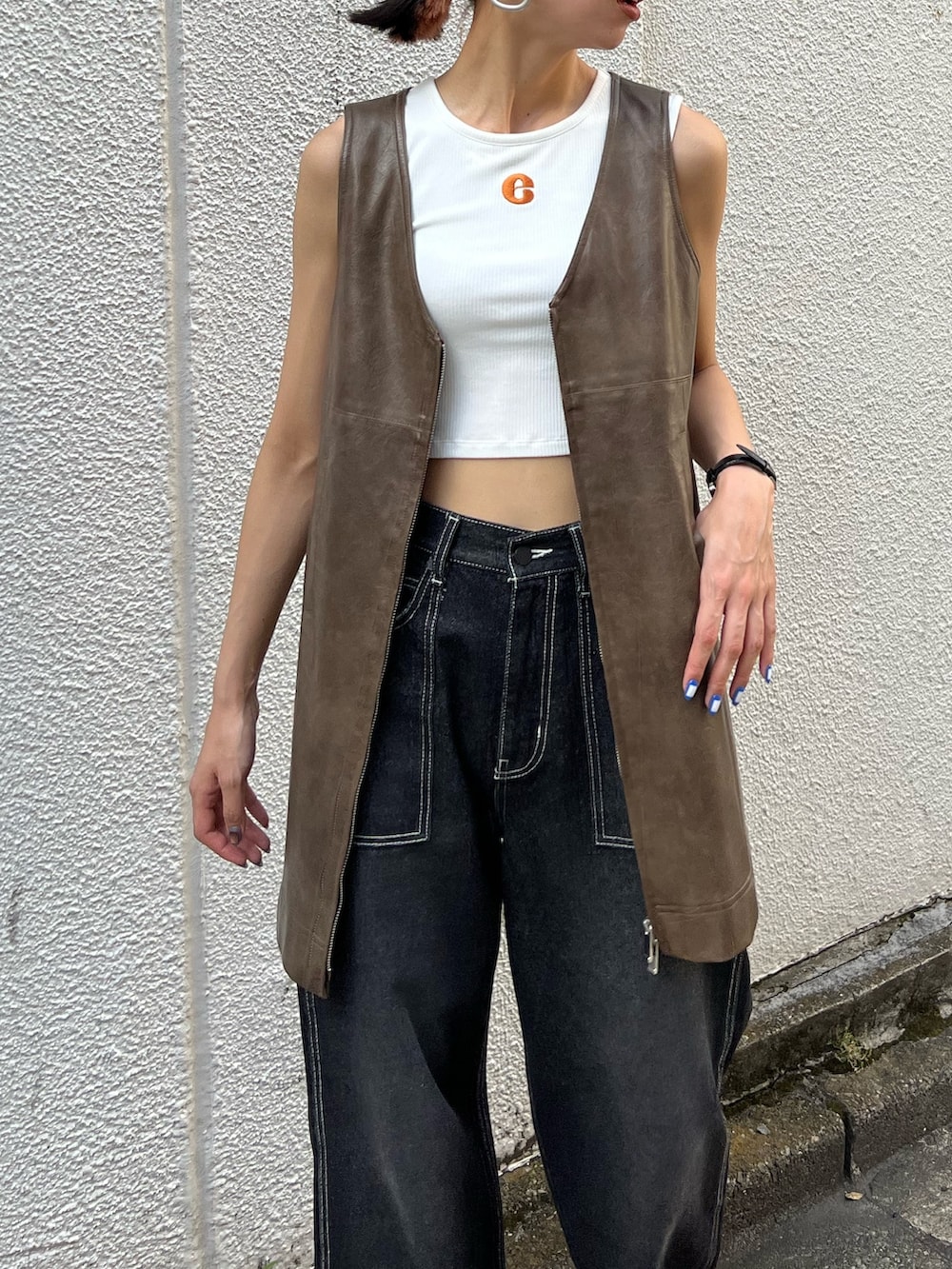 ブラック系のデニムパンツ、ブラック系のワンピース、ホワイト系のタンクトップを着用したレディースの夏コーディネートの3枚目の写真