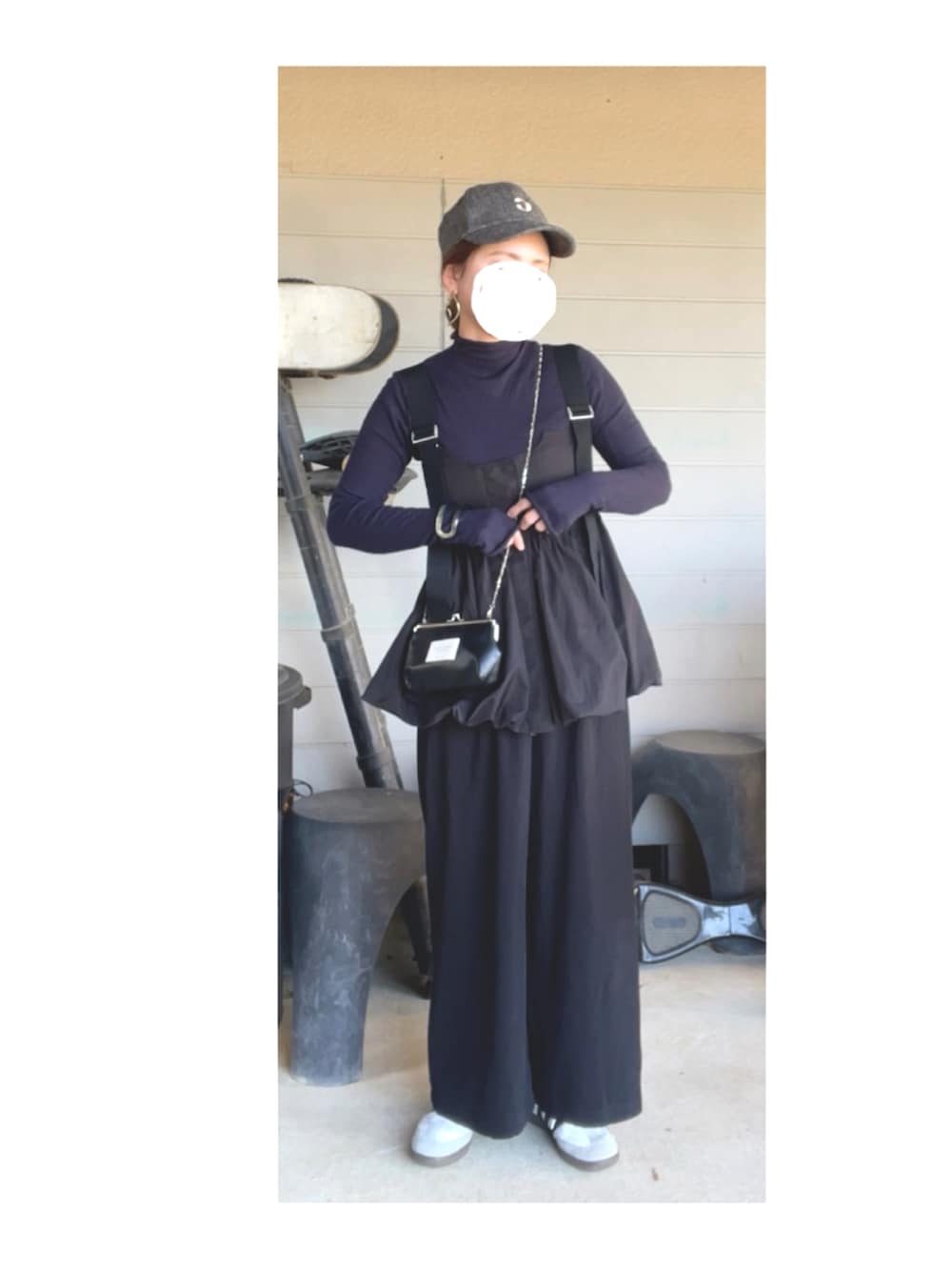 ブルー系のニット/セーター、ブラック系のベスト、ブラック系のパンツを着用したレディースの春コーディネートの2枚目の写真