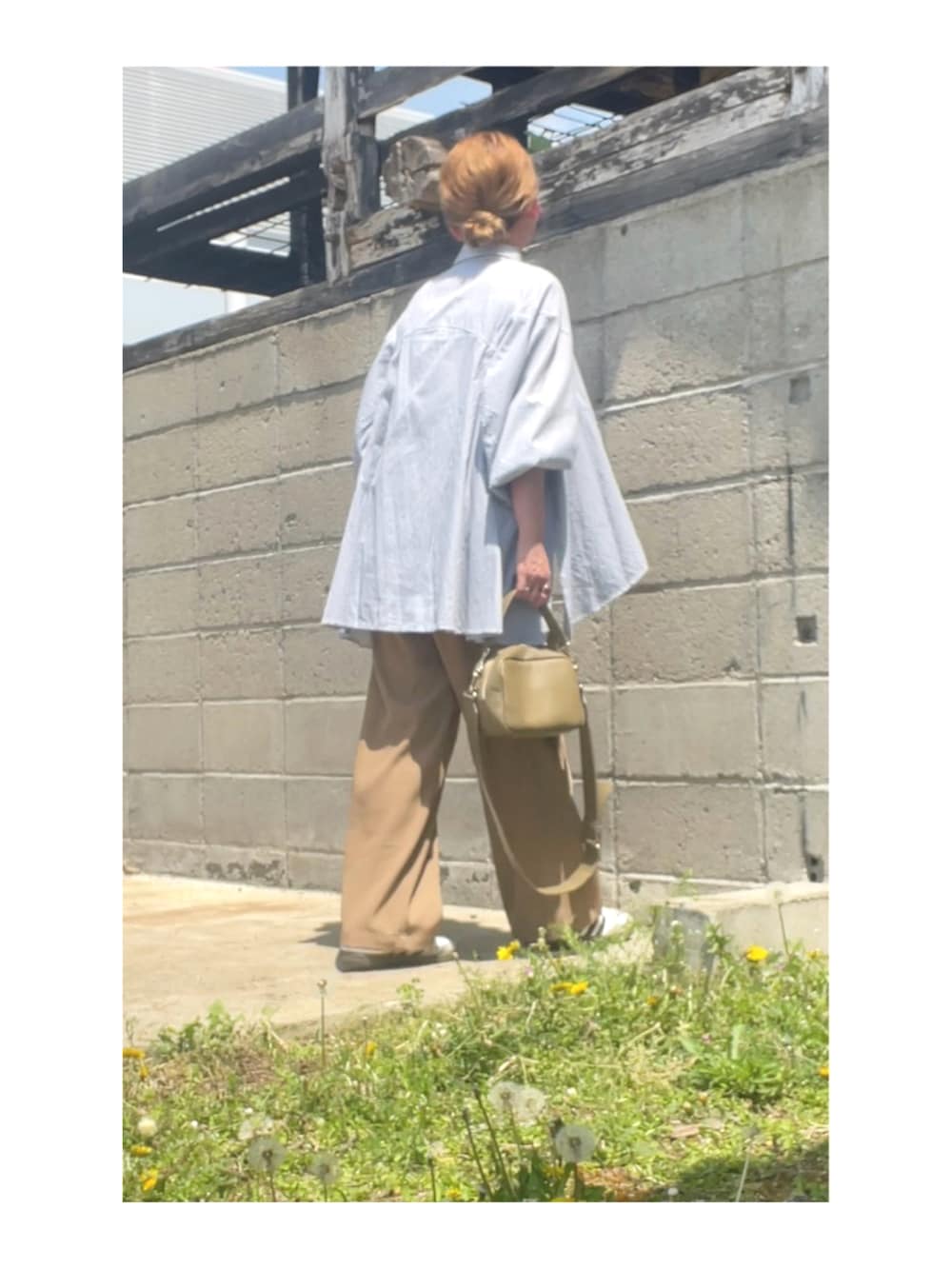 ブルー系のシャツ/ブラウス、ベージュ系のスラックス、ベージュ系のバッグを着用したレディースの春コーディネートの2枚目の写真