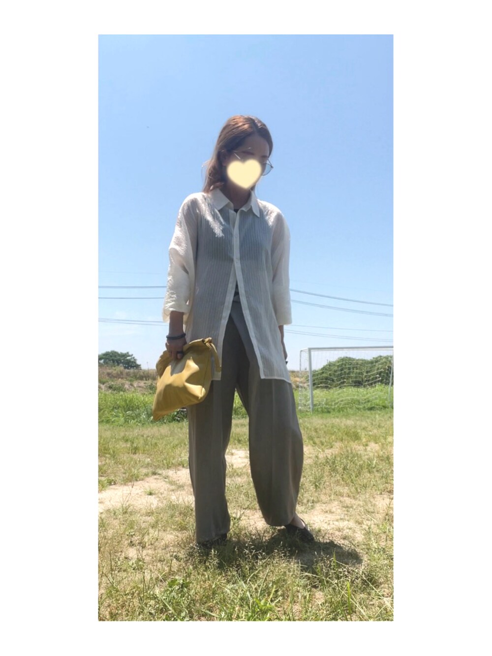 ホワイト系のシャツ/ブラウス、グレー系のパンツ、イエロー系のクラッチバッグを着用したレディースの夏コーディネートの2枚目の写真