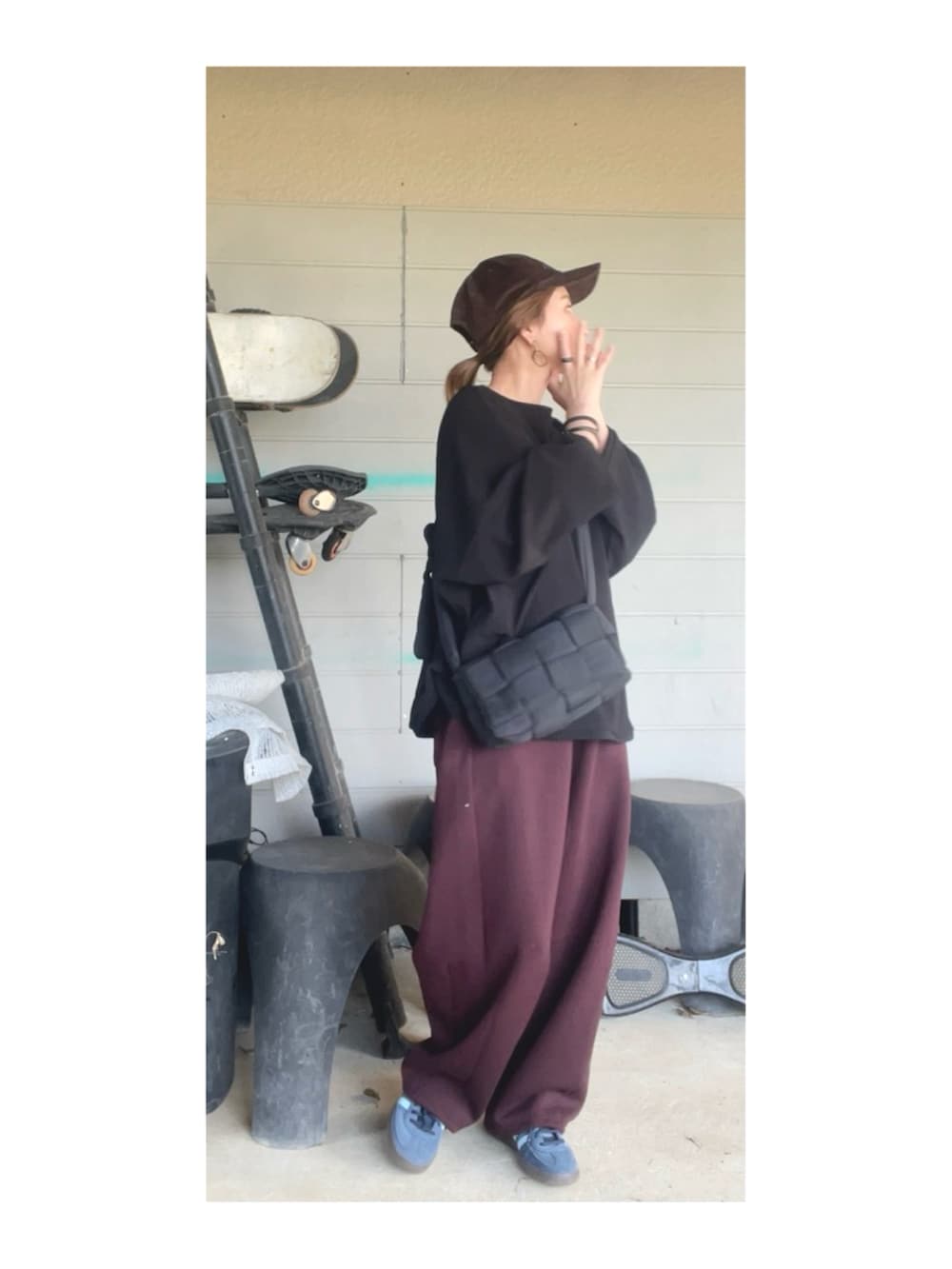 ブラック系のトップス、ブラウン系のパンツ、ブルー系のスニーカーを着用したレディースの春コーディネートの3枚目の写真