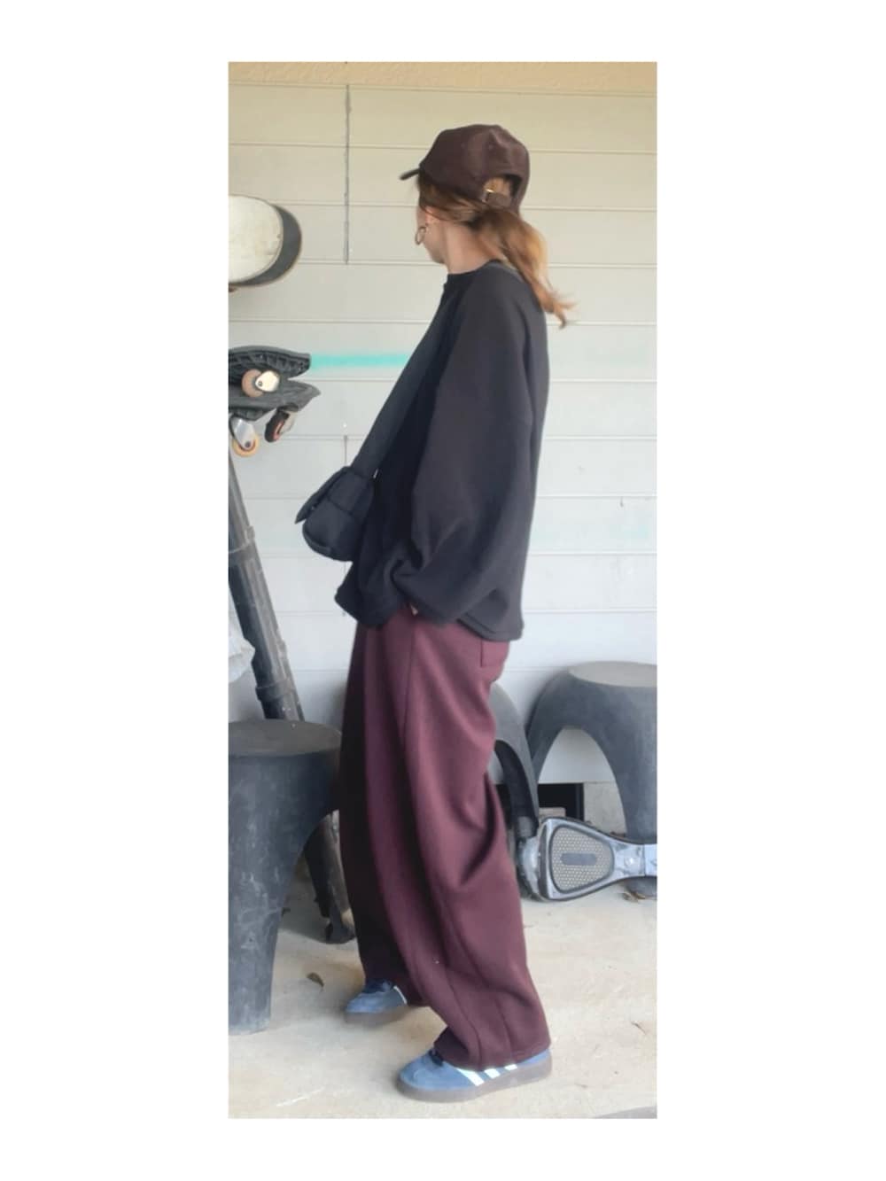 ブラック系のトップス、ブラウン系のパンツ、ブルー系のスニーカーを着用したレディースの春コーディネートの2枚目の写真