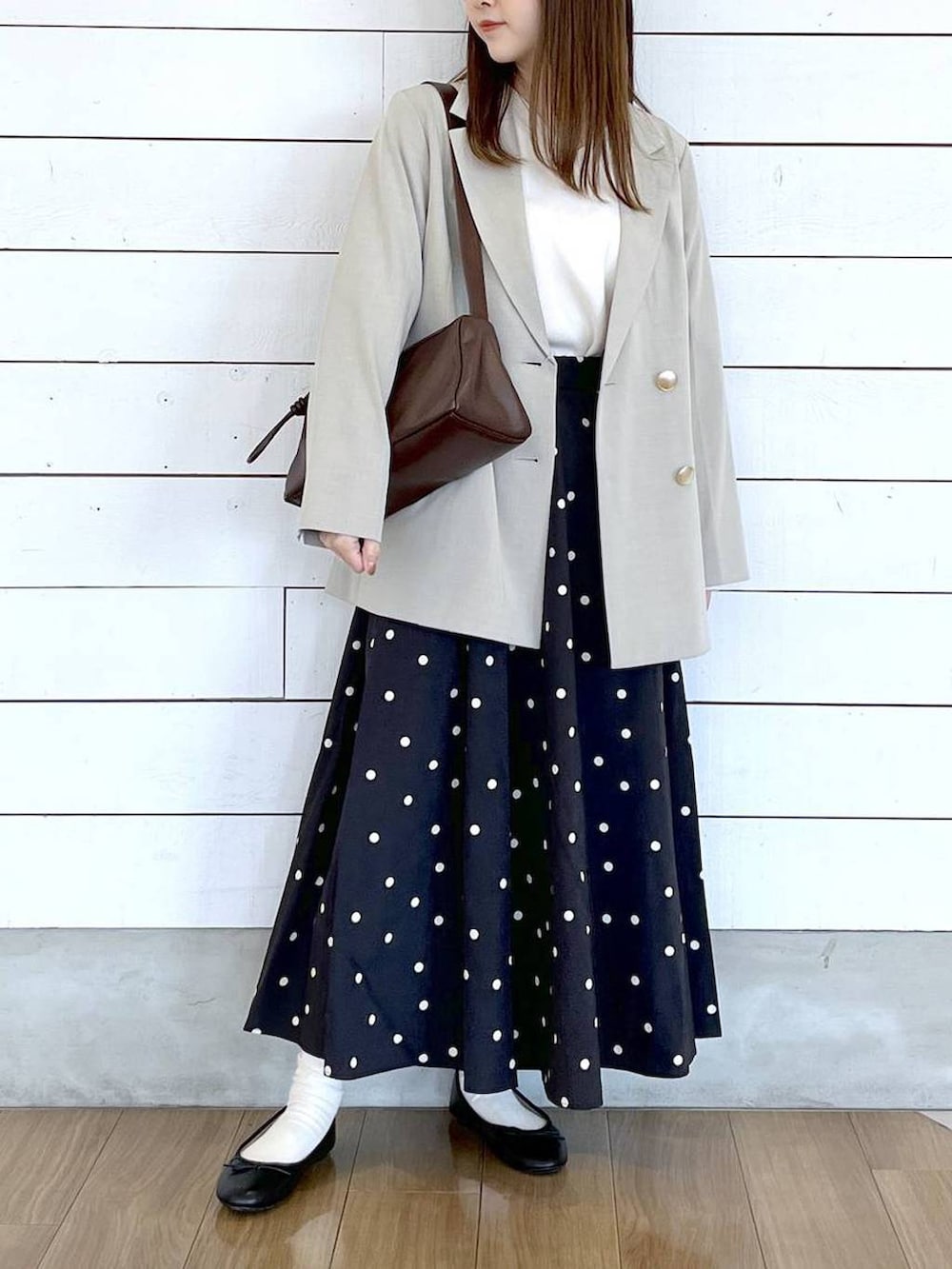 ブラック系のバレエシューズ、ベージュ系のテーラードジャケット、その他のスカートを着用したレディースの春コーディネートの4枚目の写真