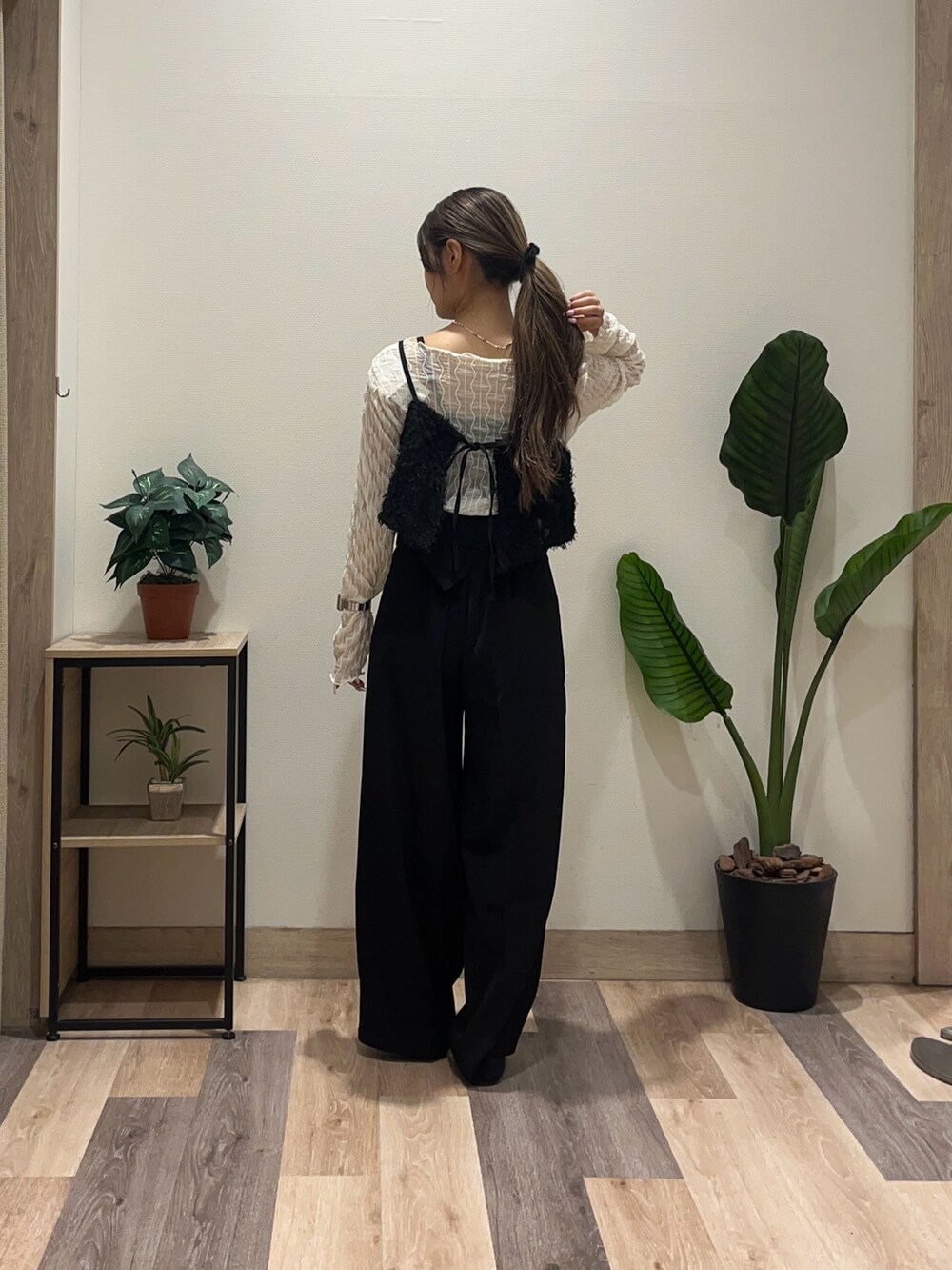 ブラック系のスラックス、ブラック系のパンプス、ホワイト系のTシャツ/カットソーを着用したレディースの秋コーディネートの4枚目の写真