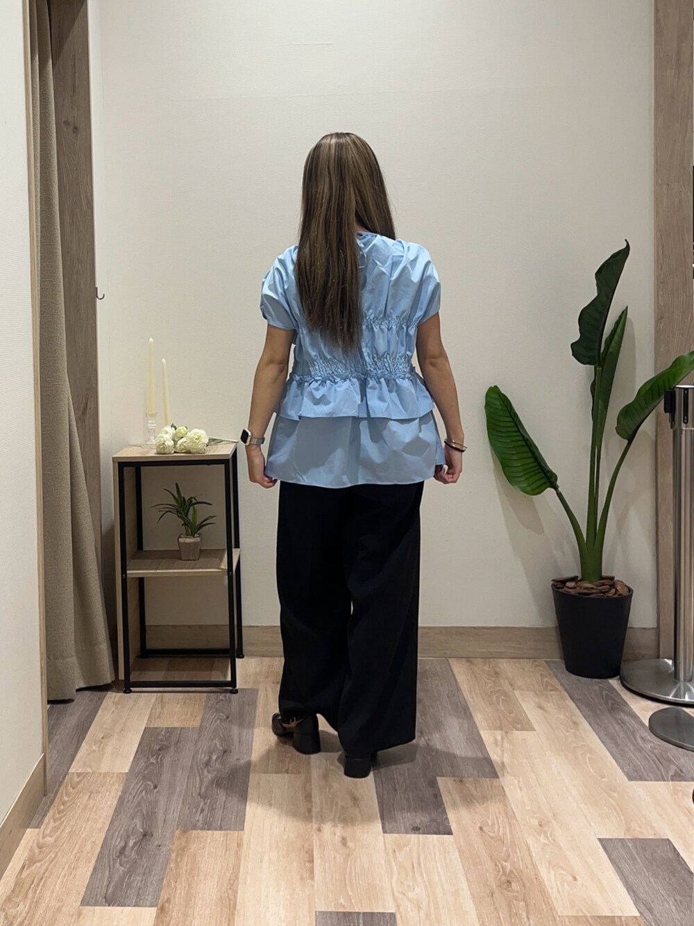 ブルー系のシャツ/ブラウス、ブラック系のスラックスを着用したレディースの夏コーディネートの3枚目の写真