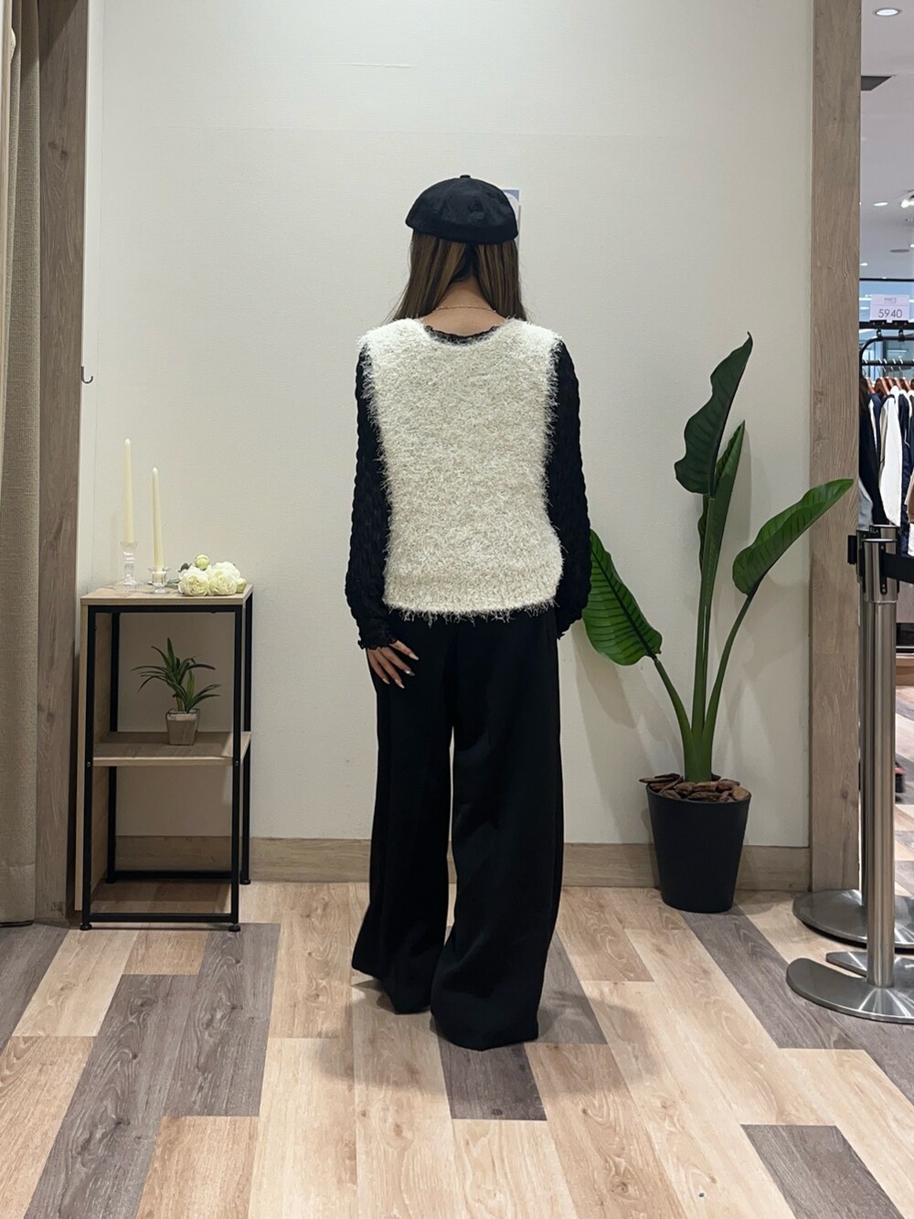 ブラック系のスラックス、ホワイト系のニット/セーター、ブラック系のTシャツ/カットソーを着用したレディースの秋コーディネートの3枚目の写真