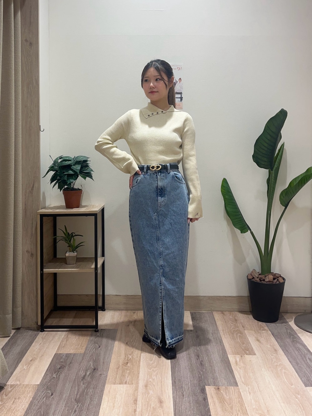 ブルー系のスカート、ホワイト系のニット/セーター、ブラック系のベルトを着用したレディースの秋コーディネートの2枚目の写真