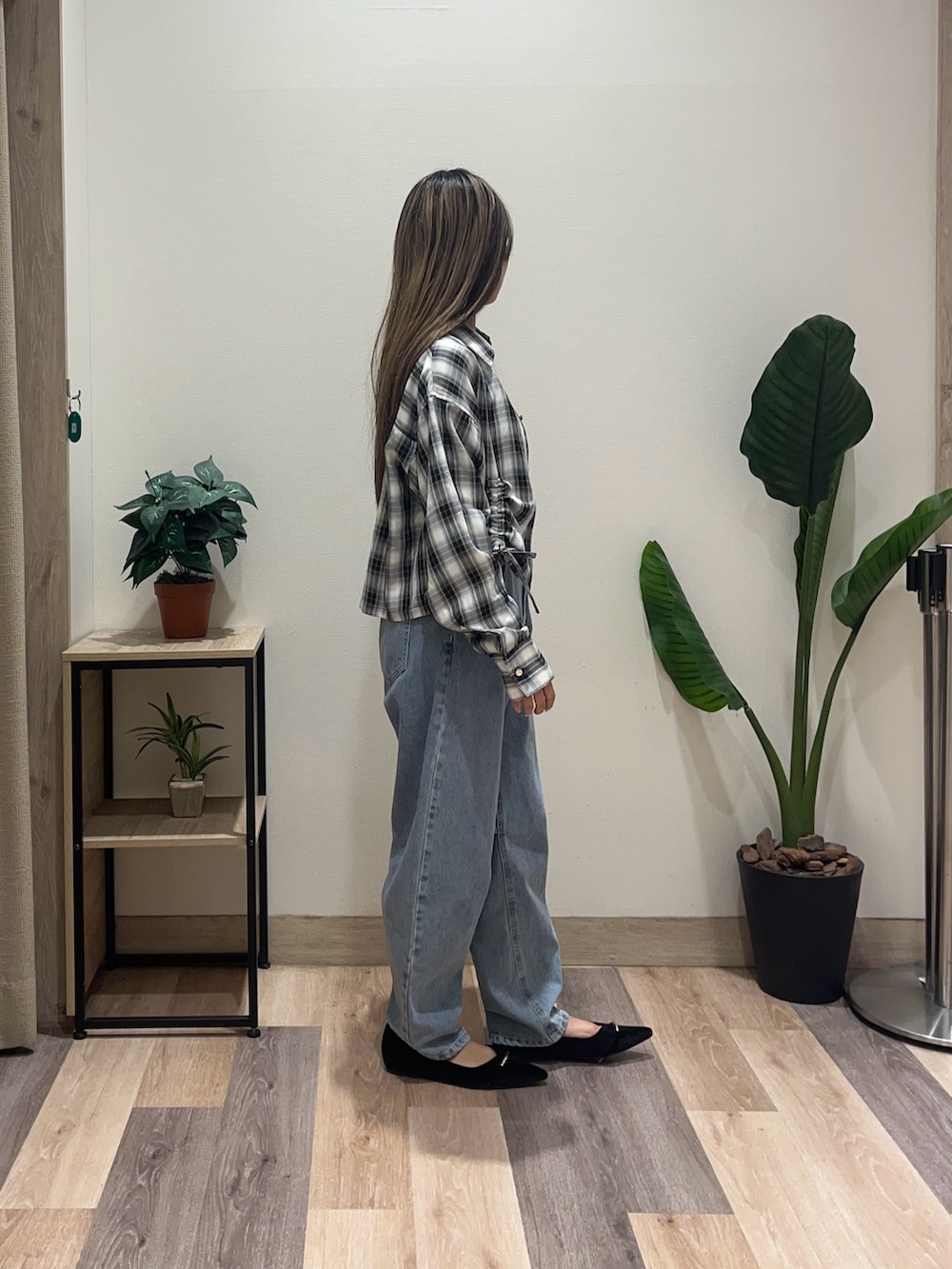 ブルー系のデニムパンツ、ブラック系のシャツ/ブラウス、ブラック系のパンプスを着用したレディースの秋コーディネートの2枚目の写真