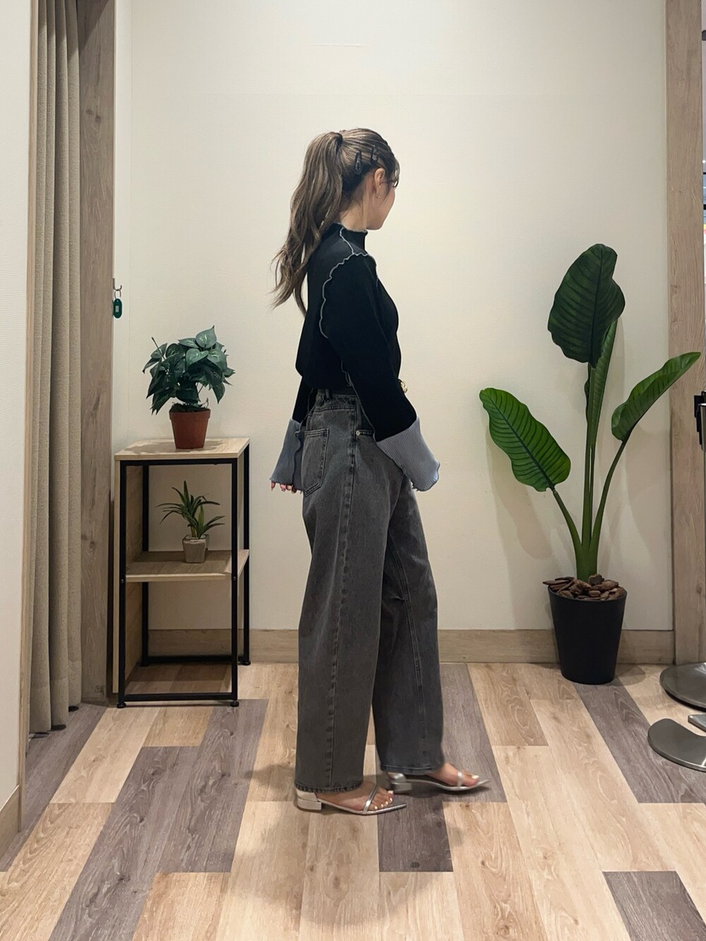 ブラック系のデニムパンツ、ブラック系のTシャツ/カットソー、ブラック系のベルトを着用したレディースの秋コーディネートの3枚目の写真