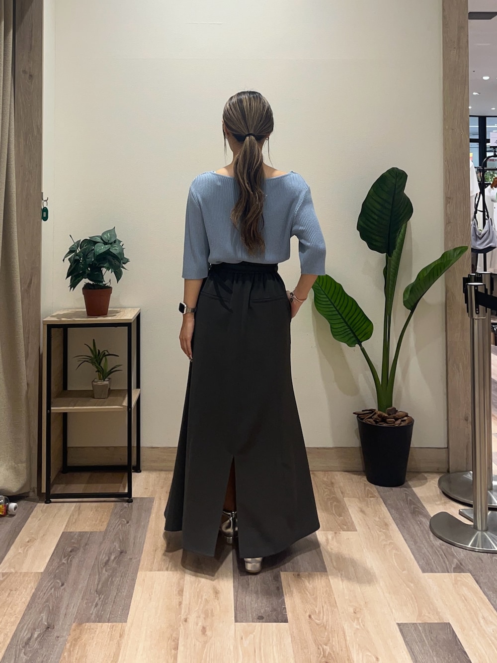 グレー系のスカート、ブルー系のニット/セーター、ブラック系のベルトを着用したレディースの秋コーディネートの4枚目の写真