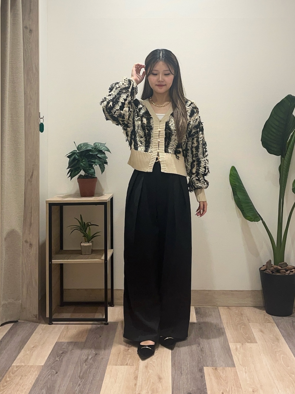 ブラック系のスラックス、ホワイト系のカーディガン/ボレロ、ブラック系のパンプスを着用したレディースの秋コーディネートの4枚目の写真