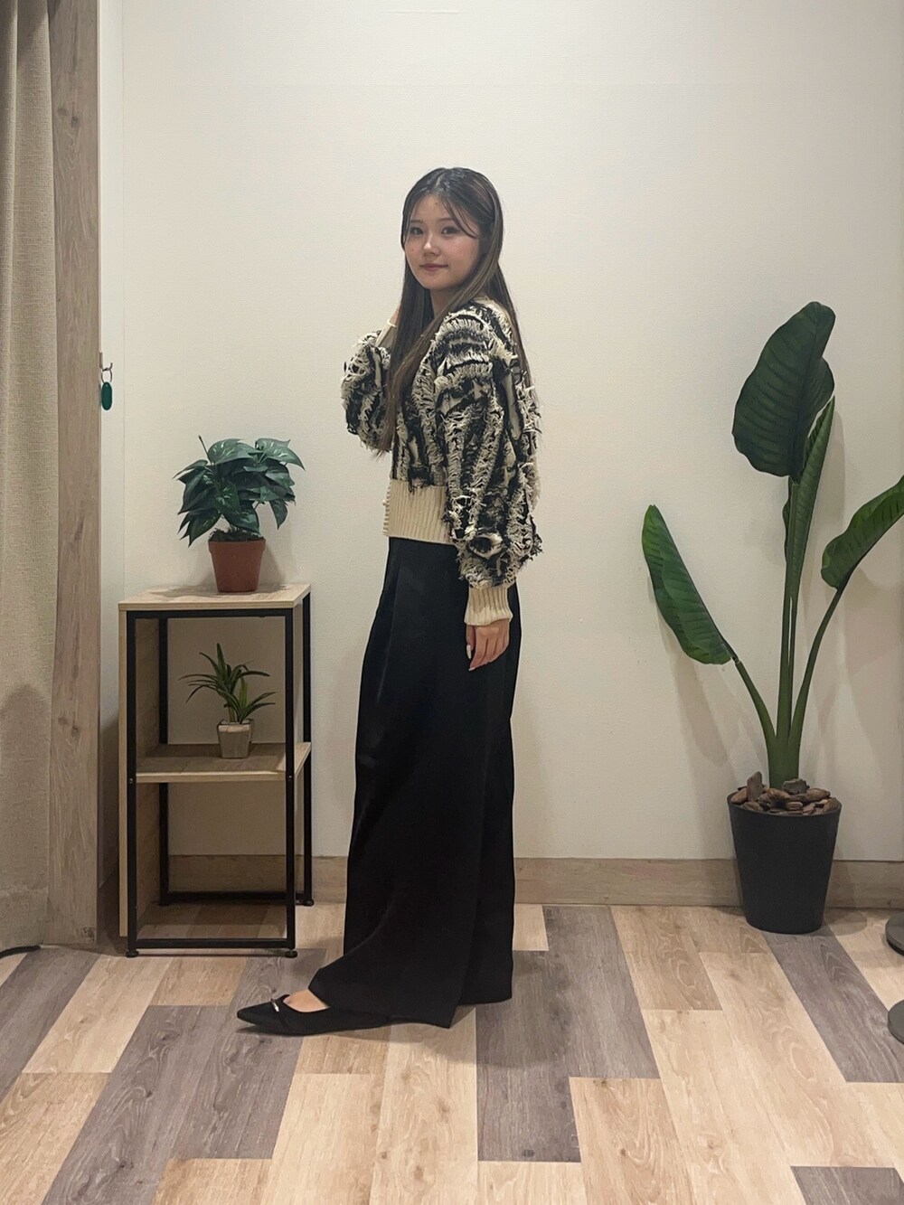 ブラック系のスラックス、ホワイト系のカーディガン/ボレロ、ブラック系のパンプスを着用したレディースの秋コーディネートの3枚目の写真