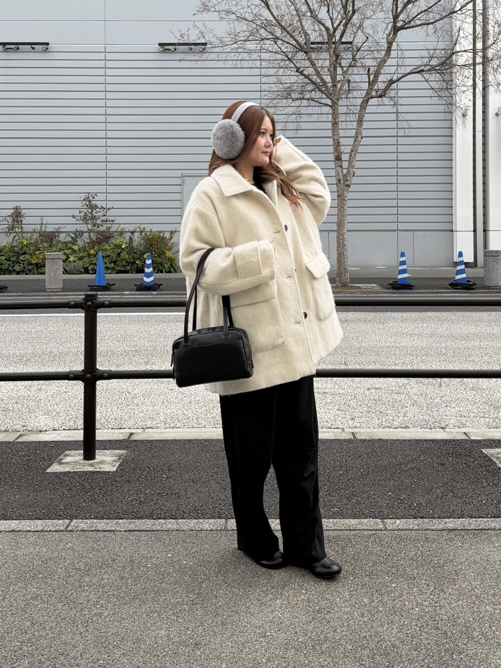 ホワイト系のその他アウター、ブラック系のニット/セーター、ブラック系のブーツを着用したレディースの冬コーディネートの2枚目の写真