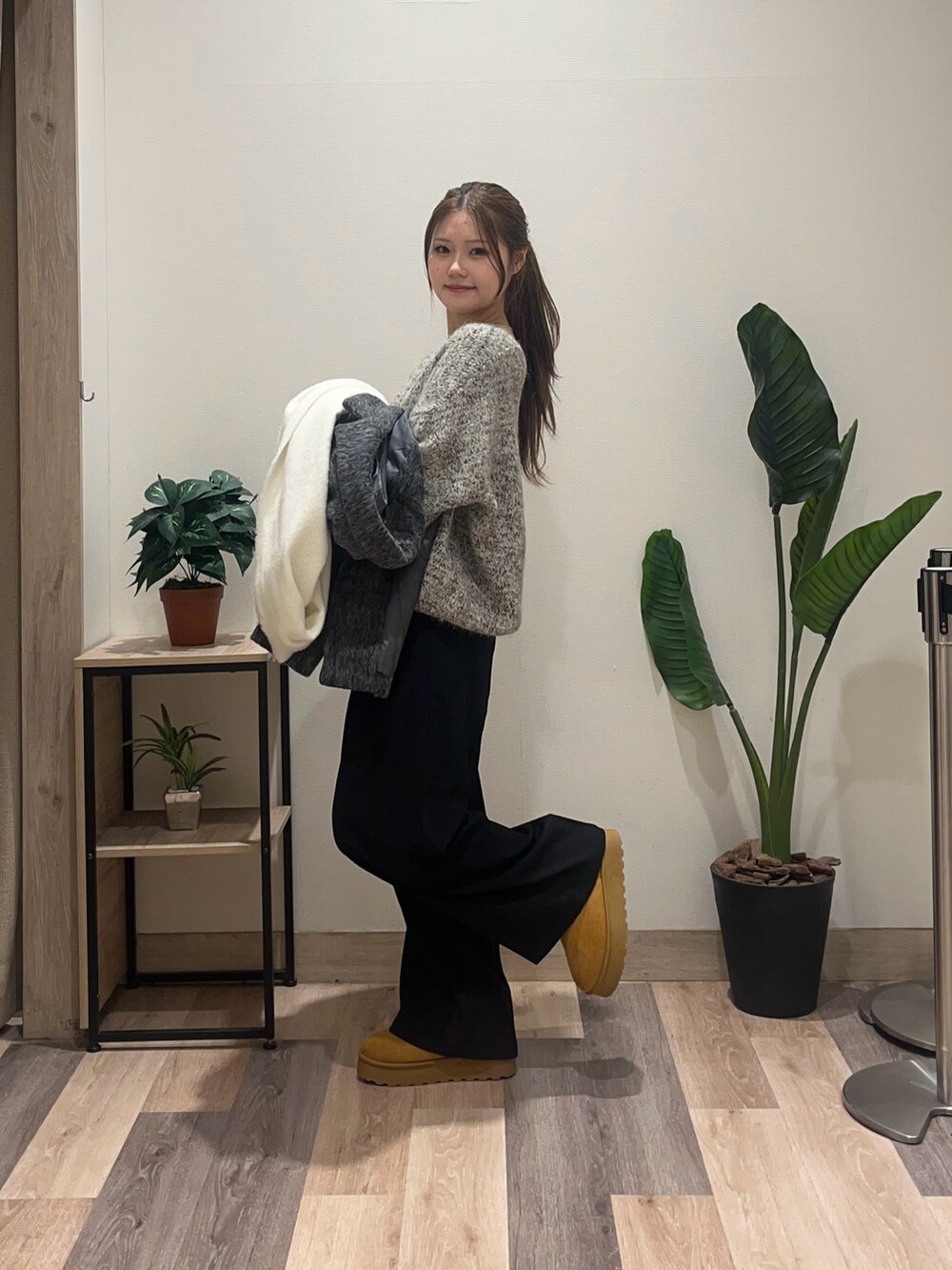 ブラウン系のニット/セーター、グレー系のその他アウター、ブラック系のスラックスを着用したレディースの冬コーディネートの5枚目の写真