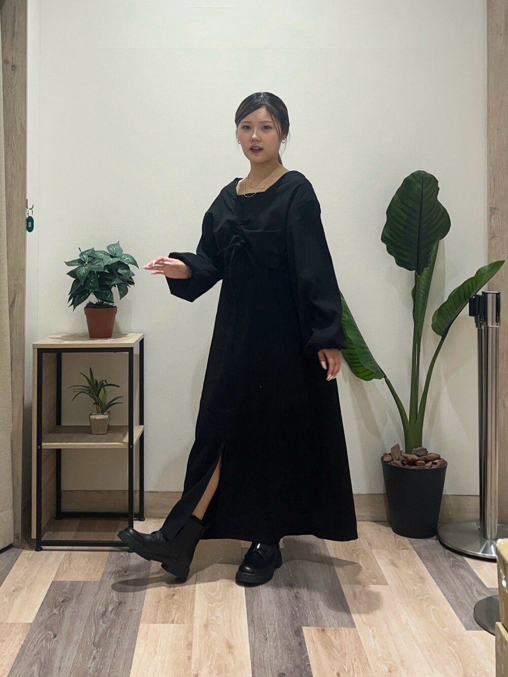 ブラック系のワンピース、ブラック系のブーツを着用したレディースの秋コーディネートの5枚目の写真