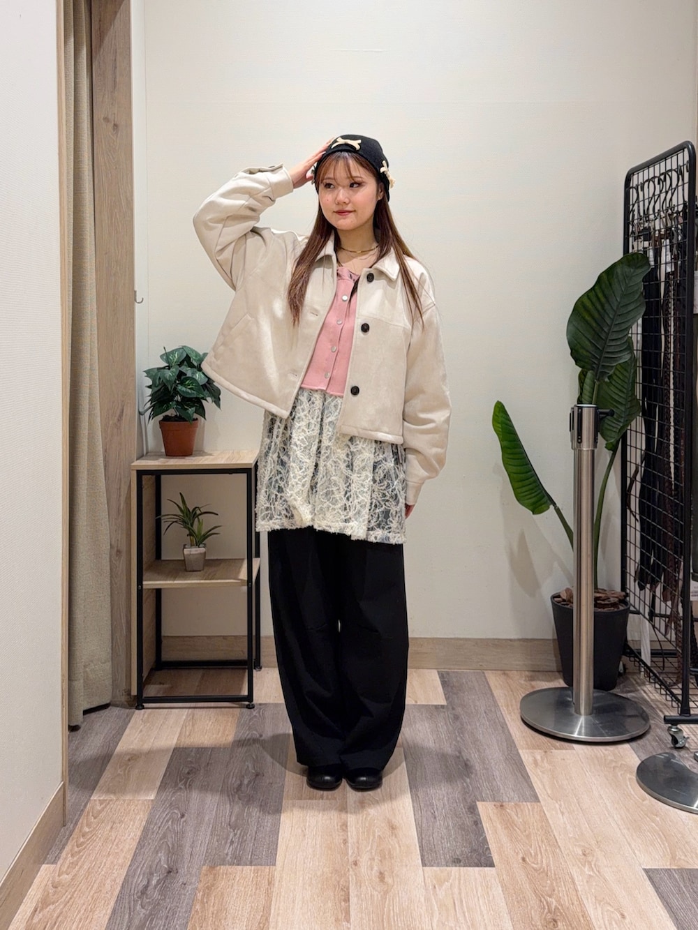 イエロー系のブルゾン、ブラック系のブーツ、ホワイト系のチュニックを着用したレディースの冬コーディネートの2枚目の写真