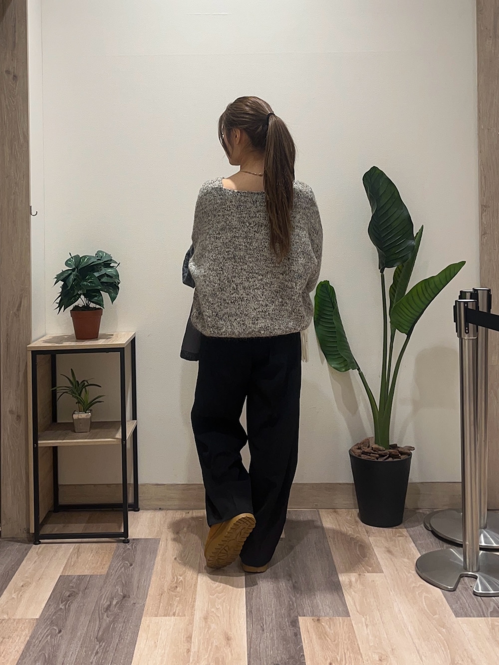 ブラウン系のニット/セーター、グレー系のその他アウター、ブラック系のスラックスを着用したレディースの冬コーディネートの4枚目の写真