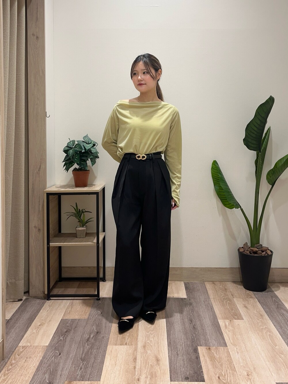 グリーン系のTシャツ/カットソー、ブラック系のスラックス、ブラック系のパンプスを着用したレディースの秋コーディネートの2枚目の写真