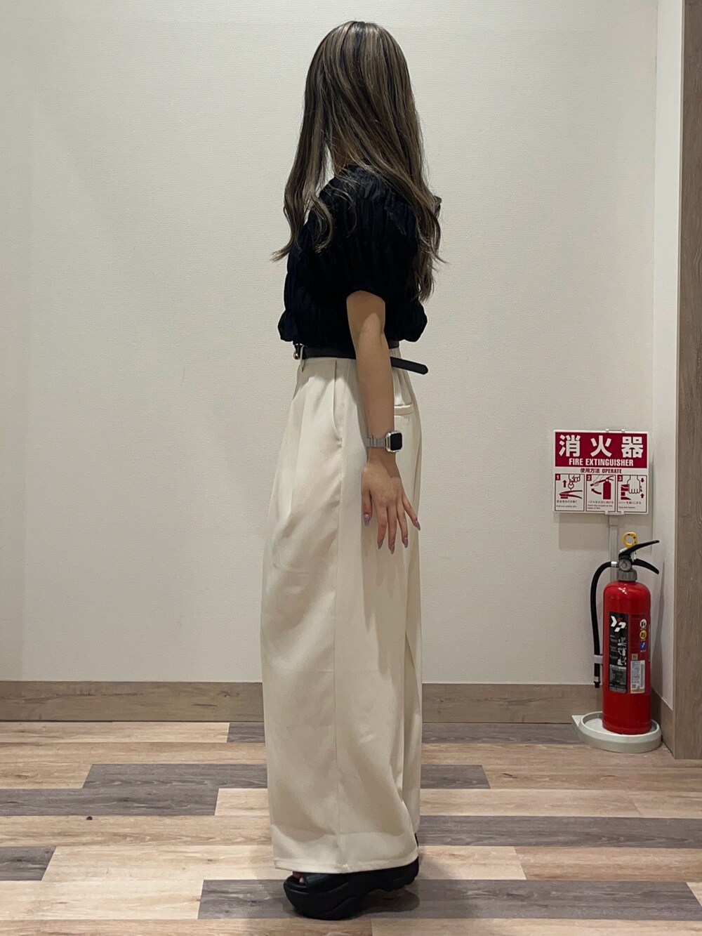 ホワイト系のスラックス、ブラック系のシャツ/ブラウス、ブラック系のベルトを着用したレディースの夏コーディネートの4枚目の写真