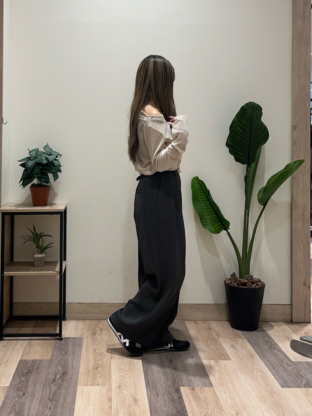 グレー系のスラックス、ベージュ系のTシャツ/カットソー、ブラック系のベルトを着用したレディースの秋コーディネートの2枚目の写真