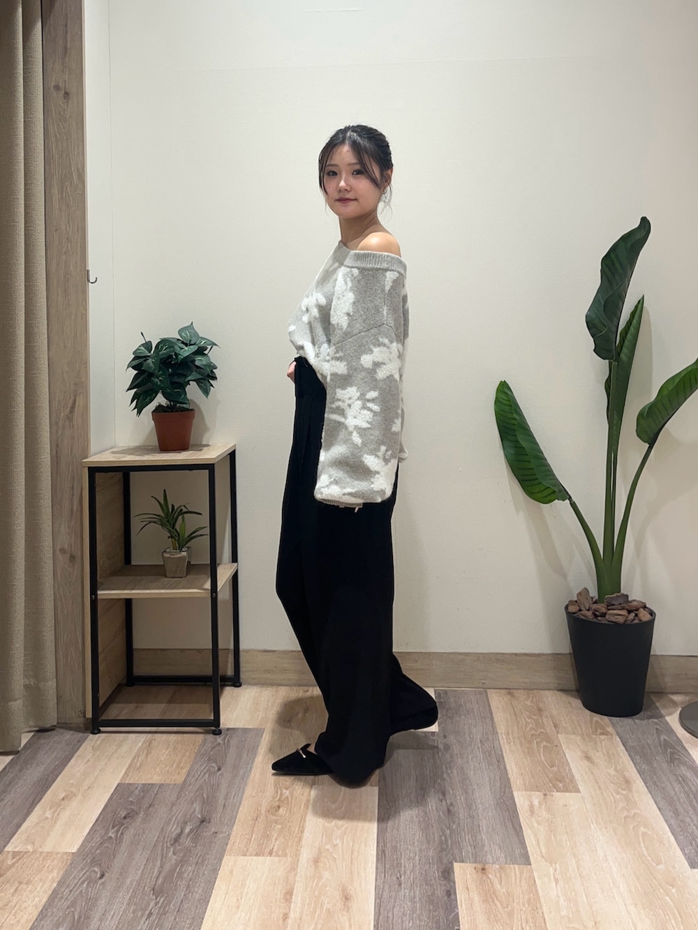 ブラック系のスラックス、グレー系のニット/セーター、ブラック系のパンプスを着用したレディースの秋コーディネートの5枚目の写真