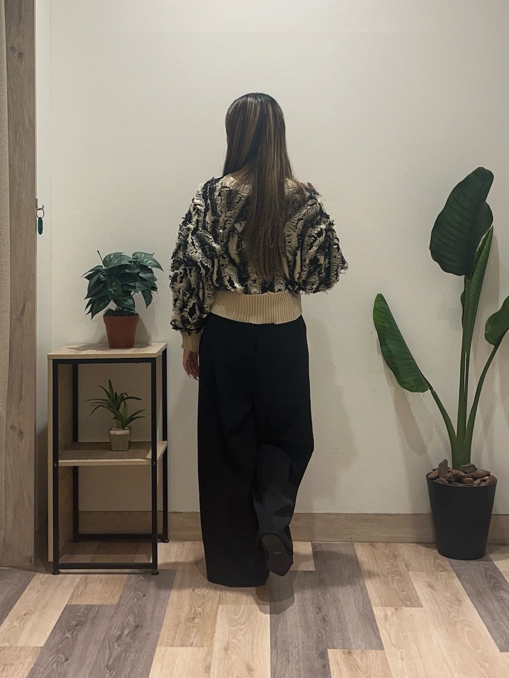 ブラック系のスラックス、ホワイト系のカーディガン/ボレロ、ブラック系のパンプスを着用したレディースの秋コーディネートの2枚目の写真