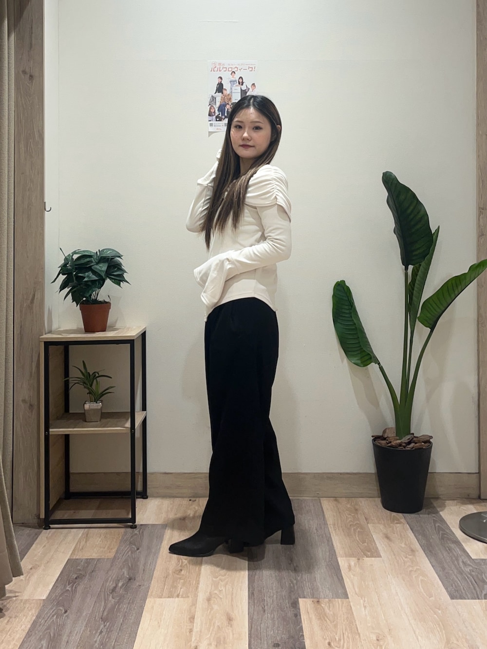 ブラック系のスラックス、ホワイト系のTシャツ/カットソー、ブラック系のブーツを着用したレディースの秋コーディネートの5枚目の写真