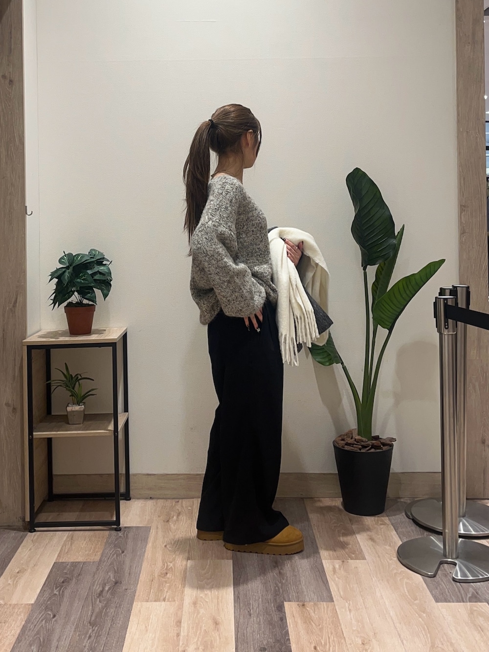 ブラウン系のニット/セーター、グレー系のその他アウター、ブラック系のスラックスを着用したレディースの冬コーディネートの3枚目の写真