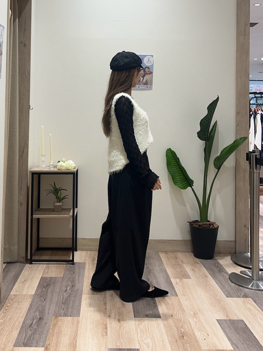 ブラック系のスラックス、ホワイト系のニット/セーター、ブラック系のTシャツ/カットソーを着用したレディースの秋コーディネートの2枚目の写真