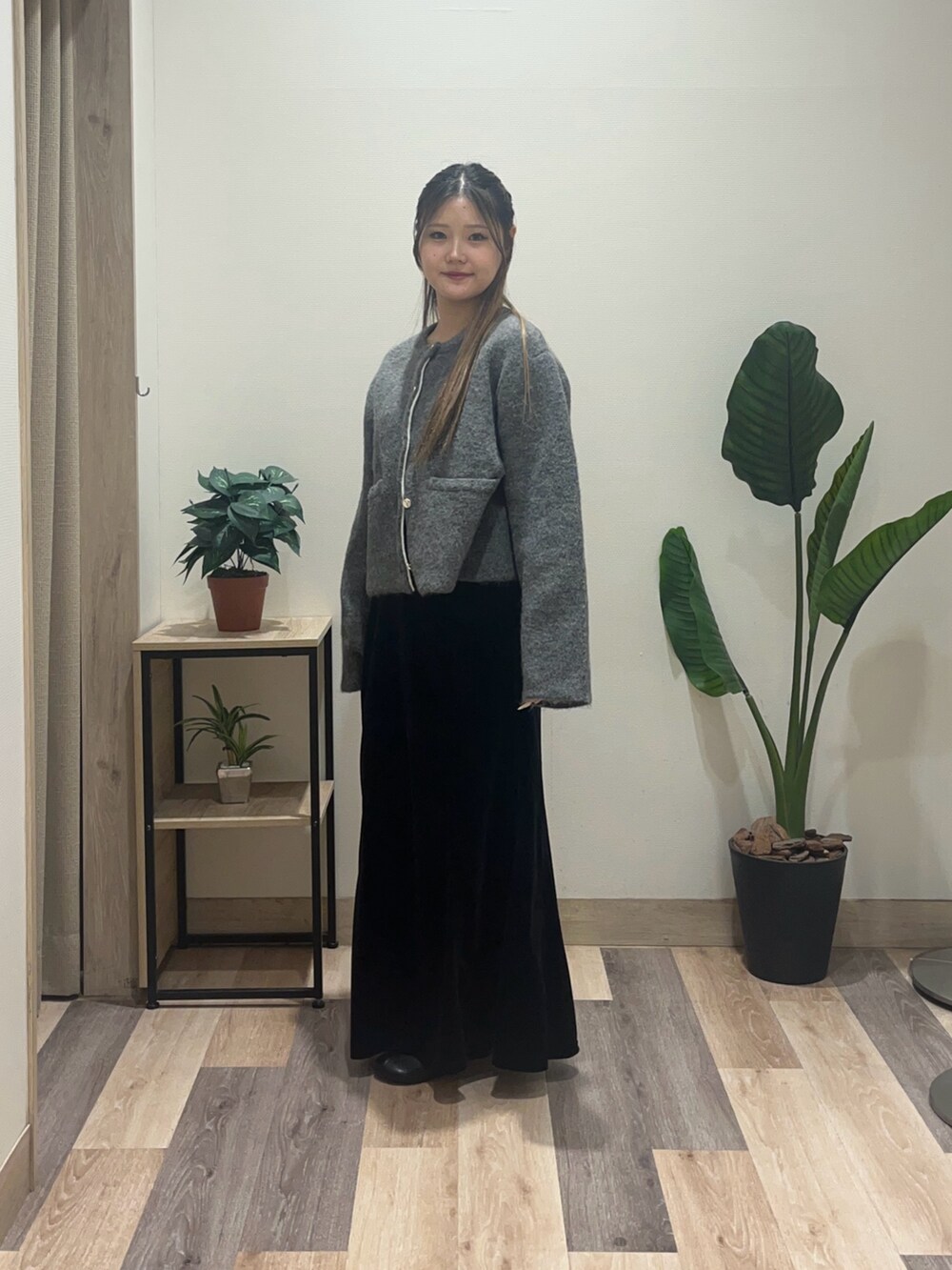 ブラック系のスカート、ブラック系のブーツ、グレー系のブルゾンを着用したレディースの冬コーディネートの5枚目の写真