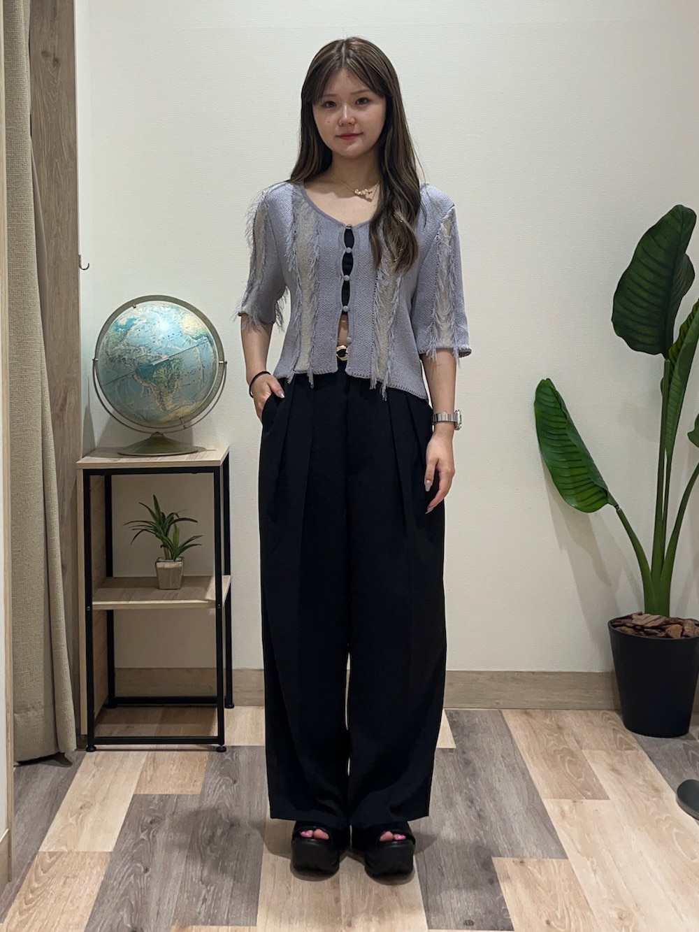 ブラック系のスラックス、ブルー系のカーディガン/ボレロ、ブラック系のベルトを着用したレディースの夏コーディネートの2枚目の写真