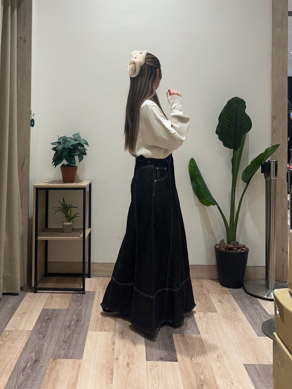 ブラック系のスカート、ブラック系のパンプス、ホワイト系のニット/セーターを着用したレディースの秋コーディネートの2枚目の写真