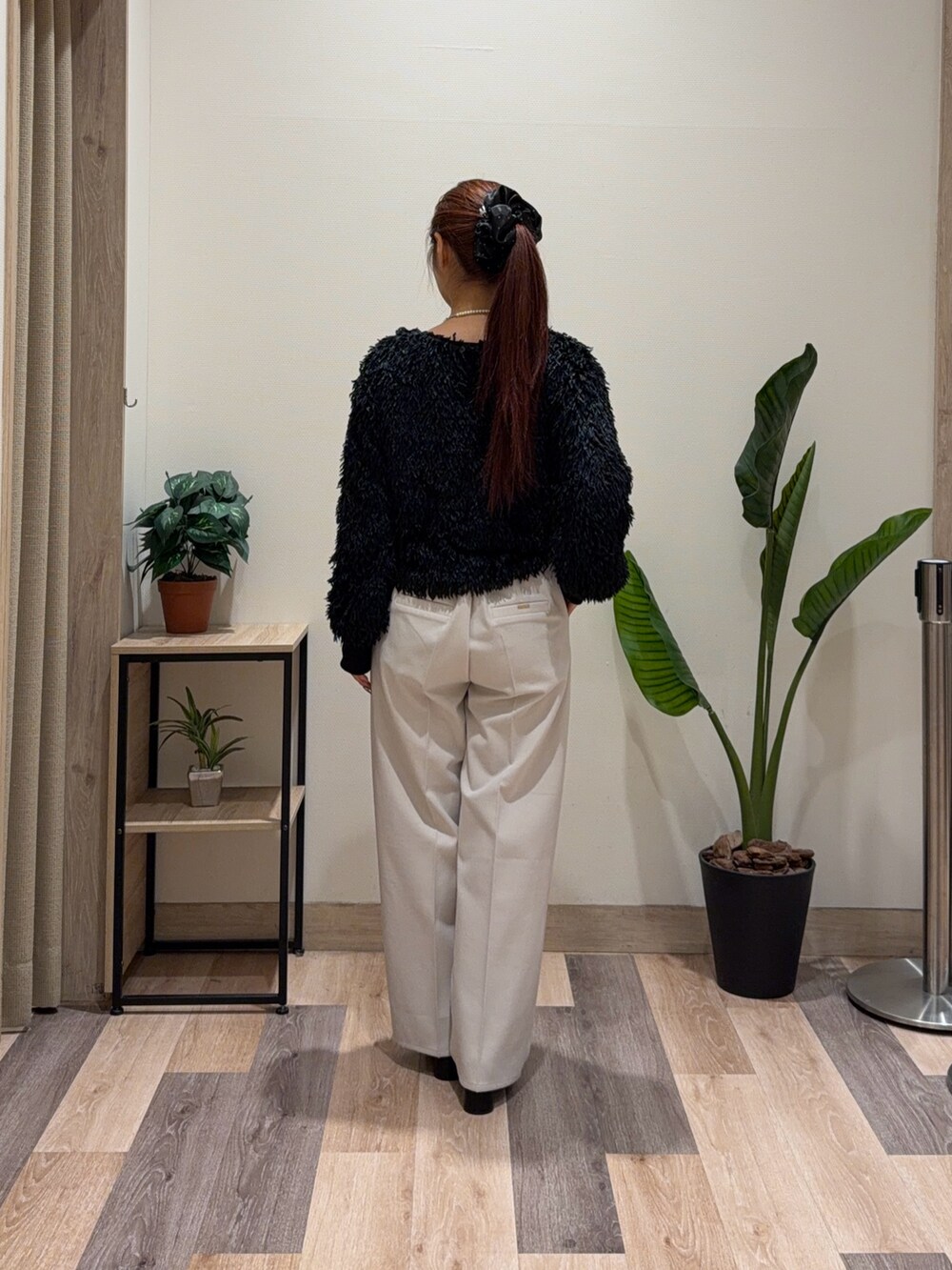 ブラック系のニット/セーター、ホワイト系のその他パンツ、ブラック系のブーツを着用したレディースの冬コーディネートの3枚目の写真