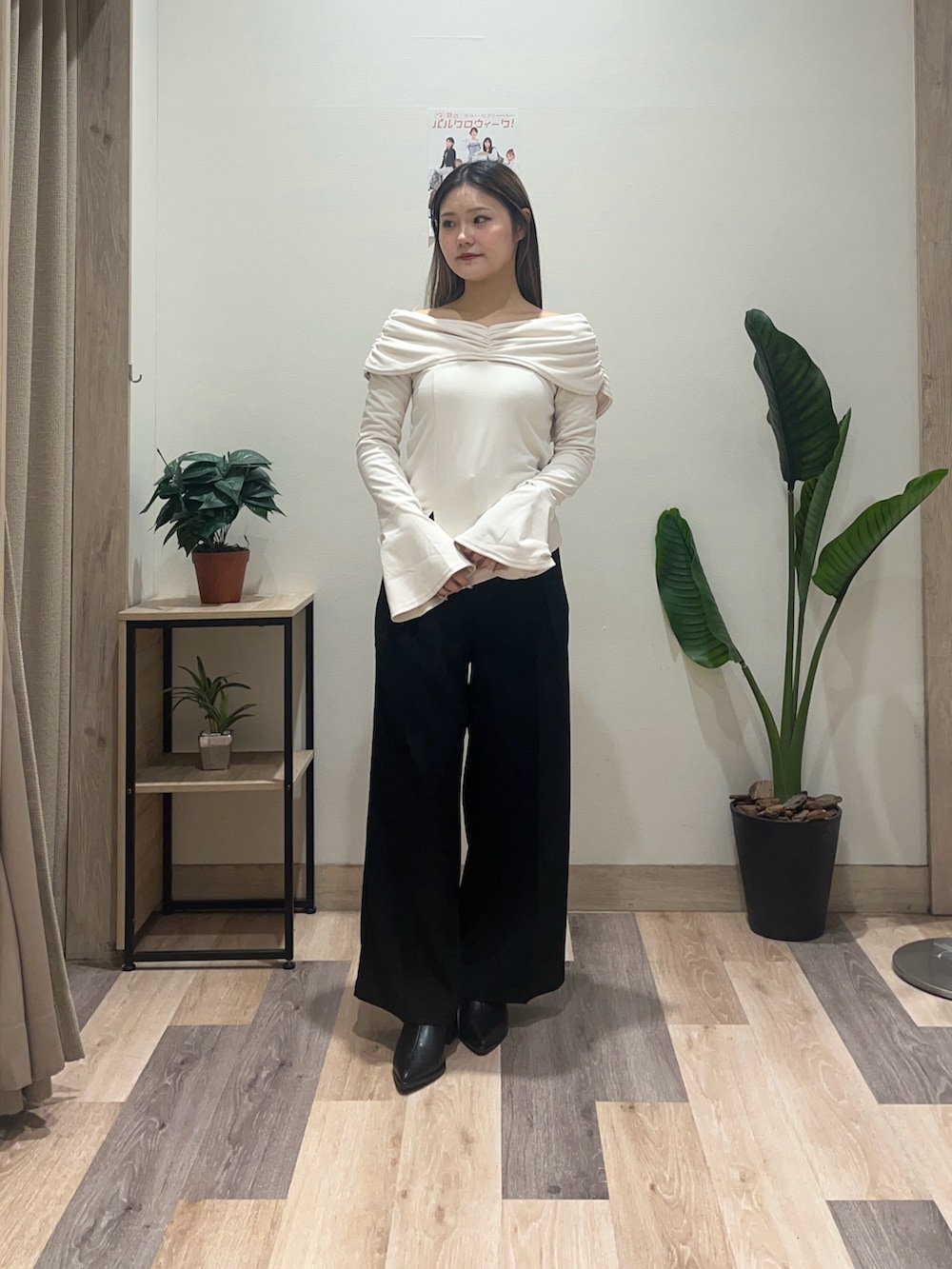 ブラック系のスラックス、ホワイト系のTシャツ/カットソー、ブラック系のブーツを着用したレディースの秋コーディネートの2枚目の写真