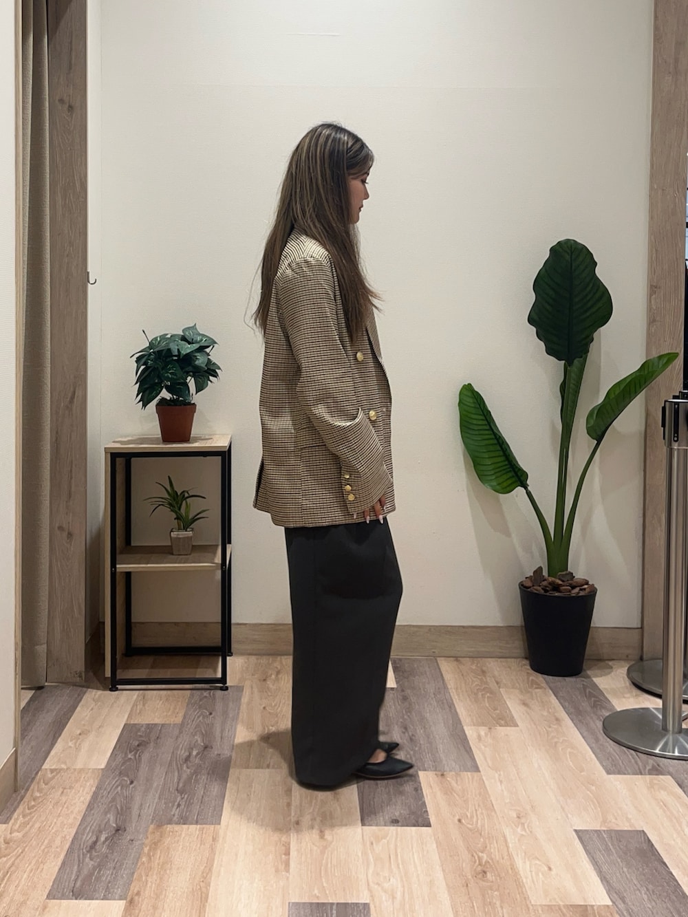 グレー系のスラックス、ベージュ系のテーラードジャケット、ブラック系のベルトを着用したレディースの秋コーディネートの2枚目の写真