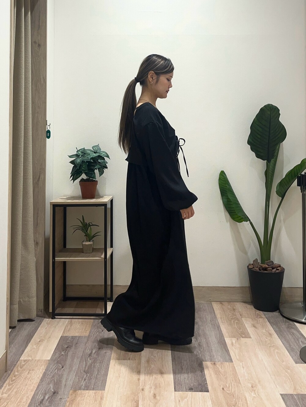 ブラック系のワンピース、ブラック系のブーツを着用したレディースの秋コーディネートの2枚目の写真