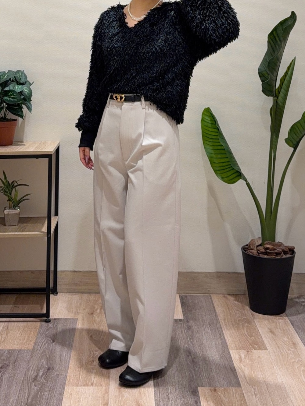 ブラック系のニット/セーター、ホワイト系のその他パンツ、ブラック系のブーツを着用したレディースの冬コーディネートの4枚目の写真