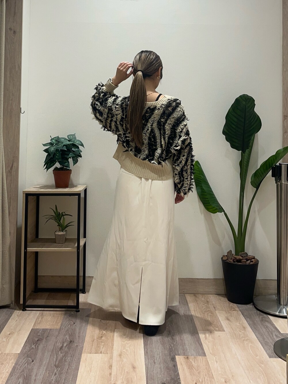 ホワイト系のスカート、ブラック系のパンプス、ブラック系のカーディガン/ボレロを着用したレディースの秋コーディネートの3枚目の写真