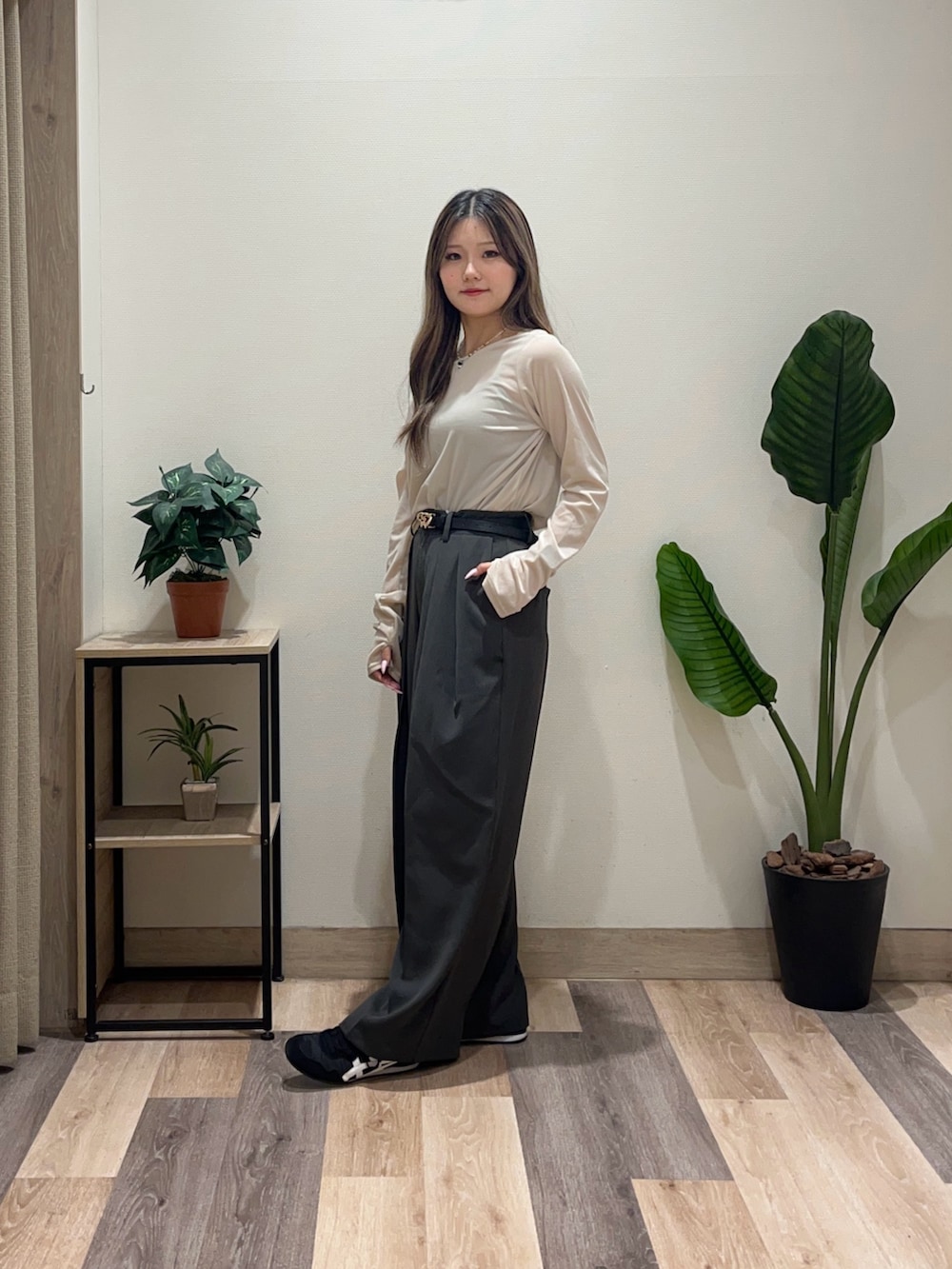 グレー系のスラックス、ベージュ系のTシャツ/カットソー、ブラック系のベルトを着用したレディースの秋コーディネートの4枚目の写真