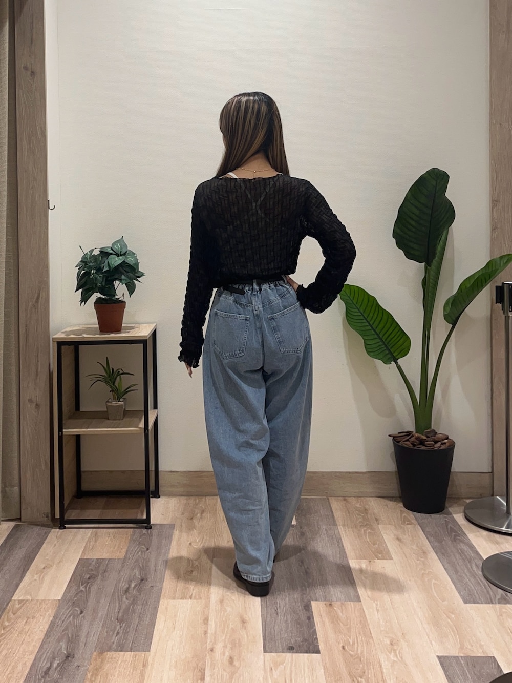 ブルー系のデニムパンツ、ブラック系のTシャツ/カットソー、ブラック系のベルトを着用したレディースの秋コーディネートの4枚目の写真