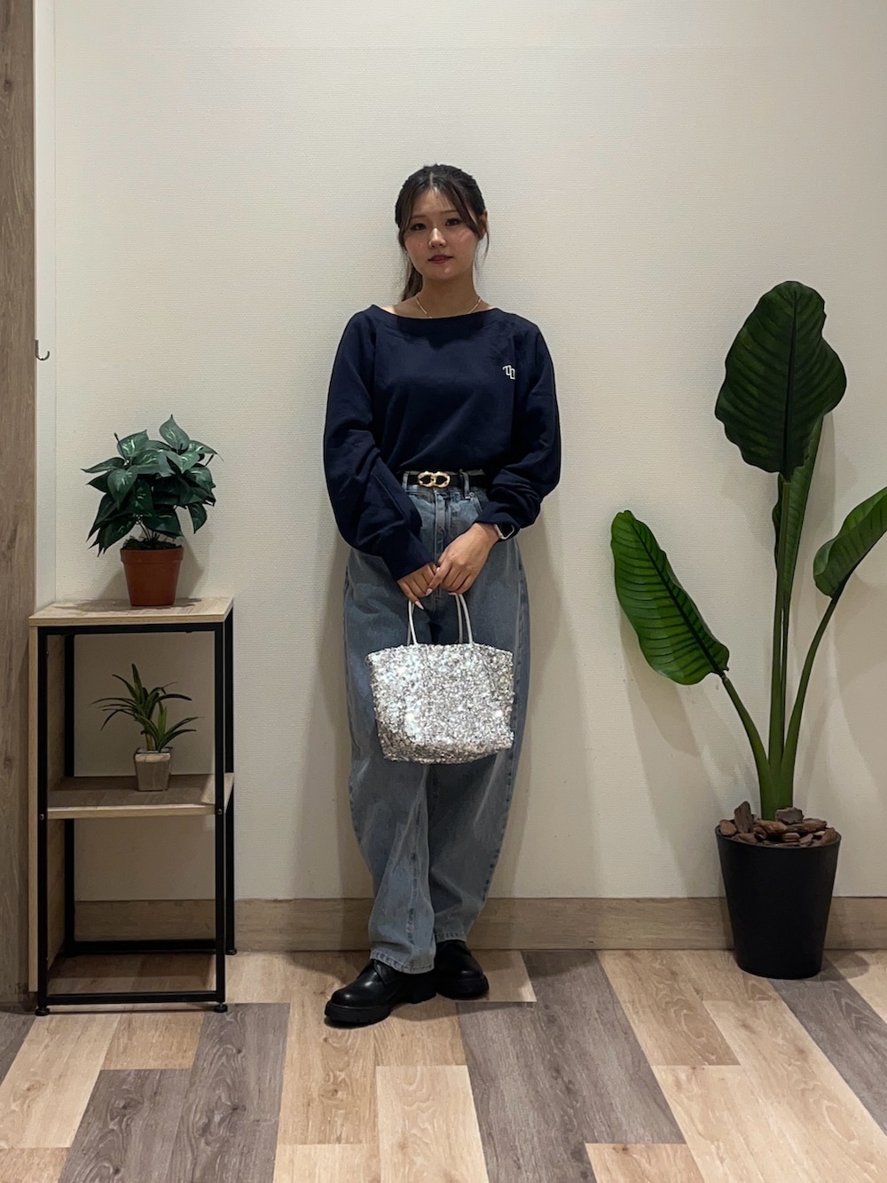 ブルー系のデニムパンツ、ブルー系のTシャツ/カットソー、ブラック系のブーツを着用したレディースの秋コーディネートの2枚目の写真